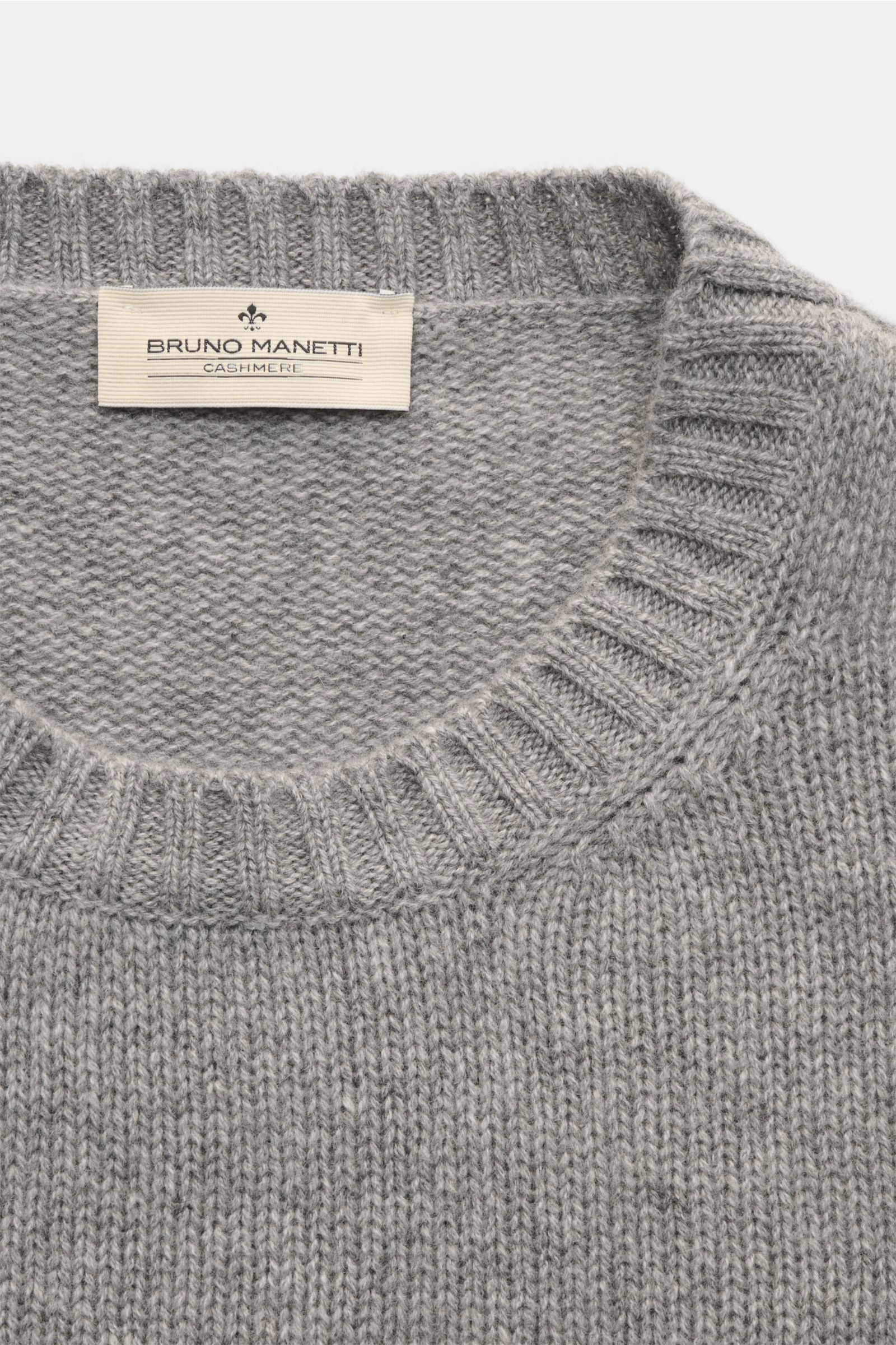 Close-up top-down view of the Bruno Manetti Cashmere Rundhalspullover grau meliert showing the round neckline, ribbed cuffs, and soft mid-fine knit texture made from pure cashmere. Einmal anziehen, nie mehr missen wollen – dieser Rundhalspullover von BRUN