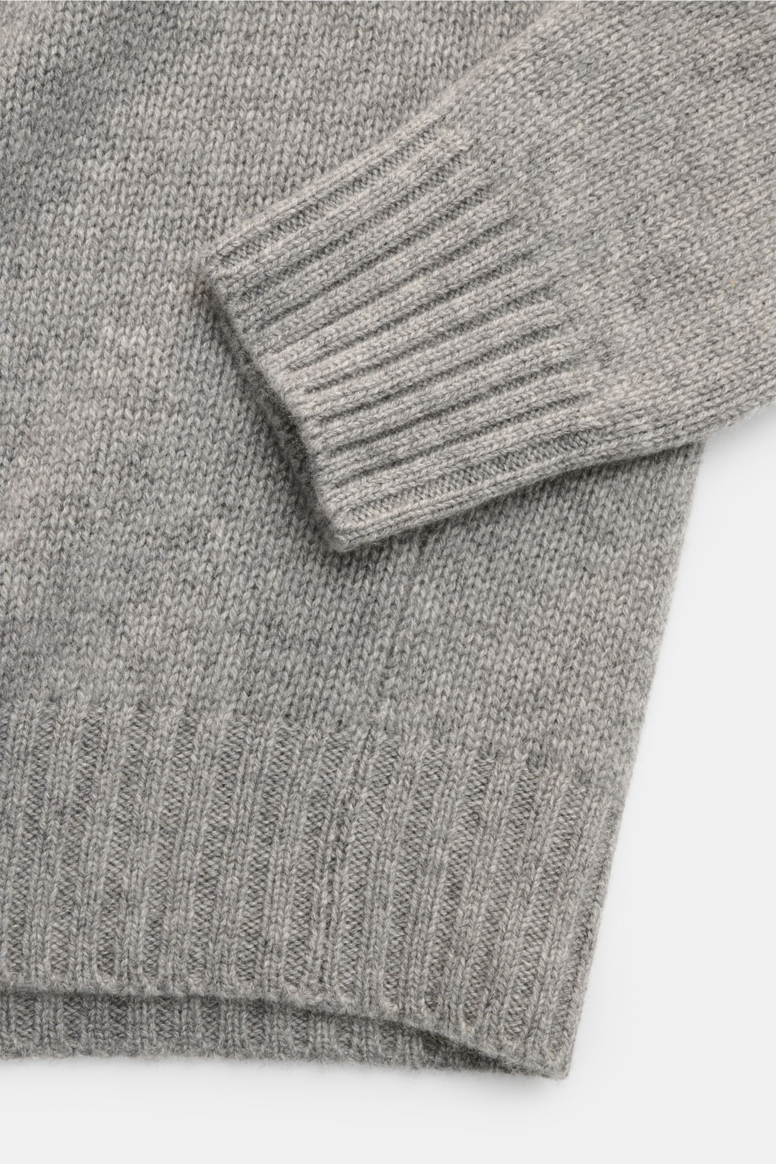 Close-up image of the sleeve and bottom hem of the Bruno Manetti Cashmere Rundhalspullover grau meliert, photographed from above, showing the soft, mid-fine knit texture and ribbed cuffs. Einmal anziehen, nie mehr missen wollen – dieser Rundhalspullove