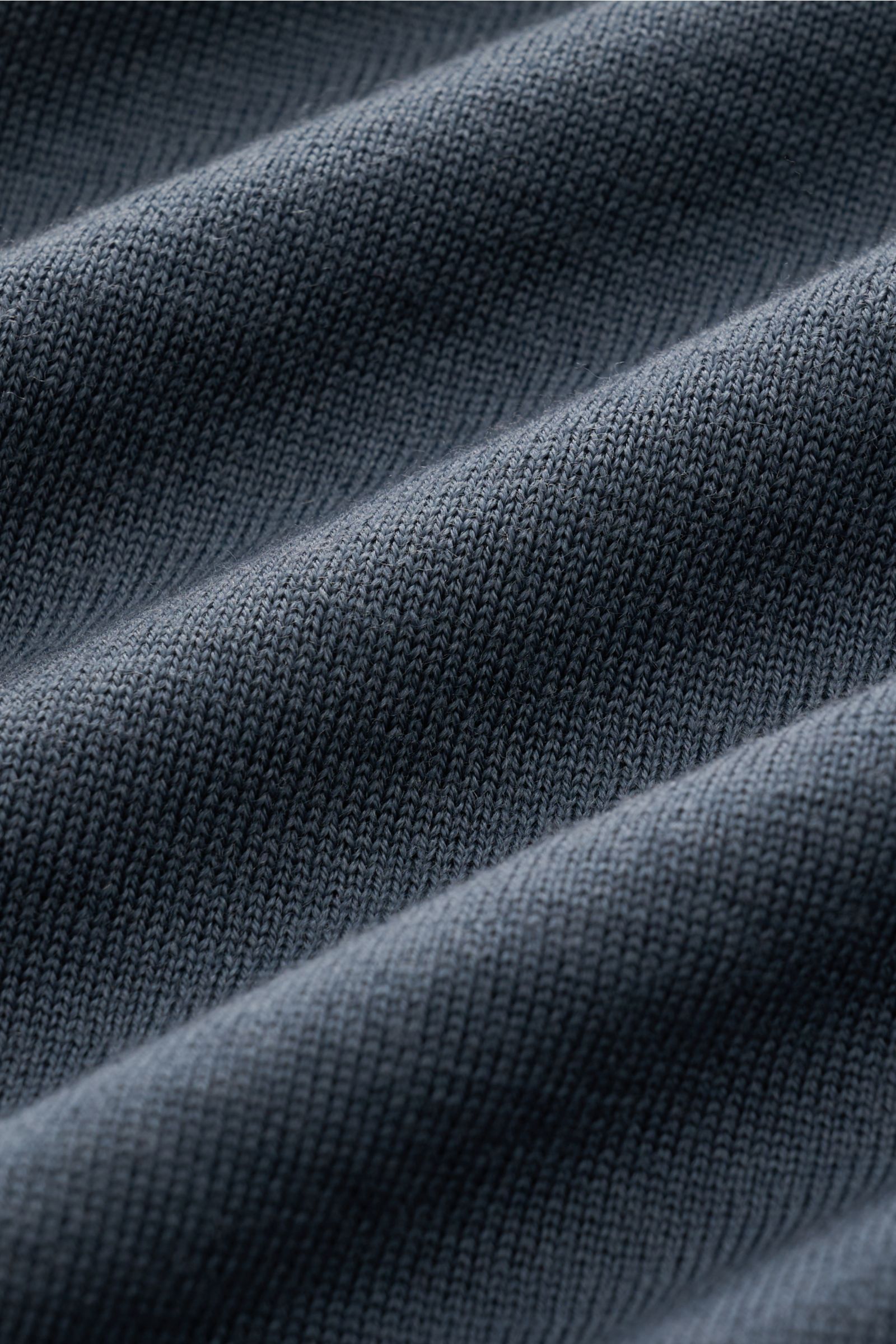Stone Island Rundhalspullover 'Ghost Piece' dunkelgrau, feines Strickbild in leichter Wolle, tonales Kompass-Badge, Detailaufnahme der Stofftextur.