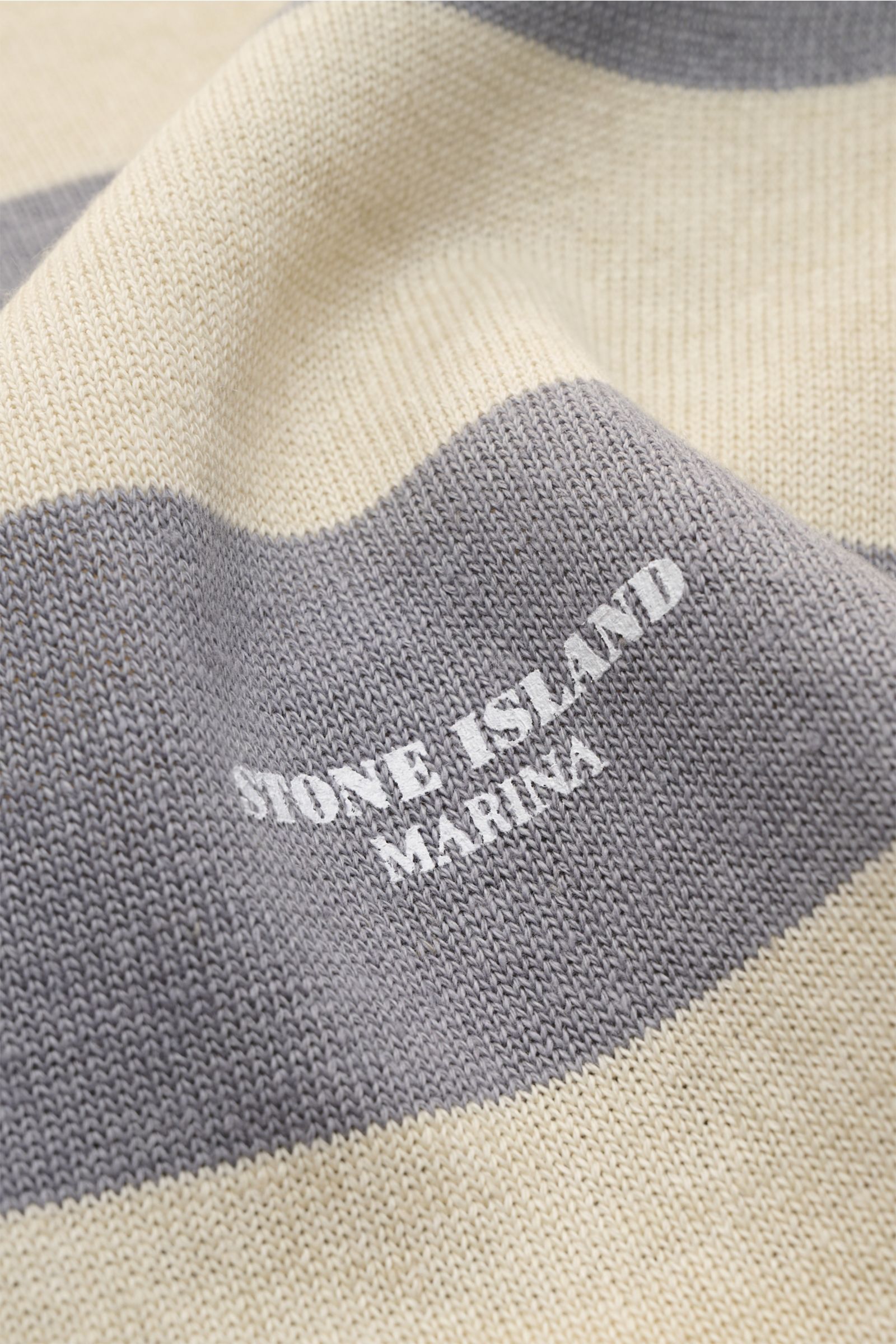 Stone Island Rundhalspullover 'Marina' grau/beige gestreift, Nahaufnahme, mittelfeines Strickbild, Baumwoll-Leinen-Mix, MARINA-Print frontal sichtbar.
