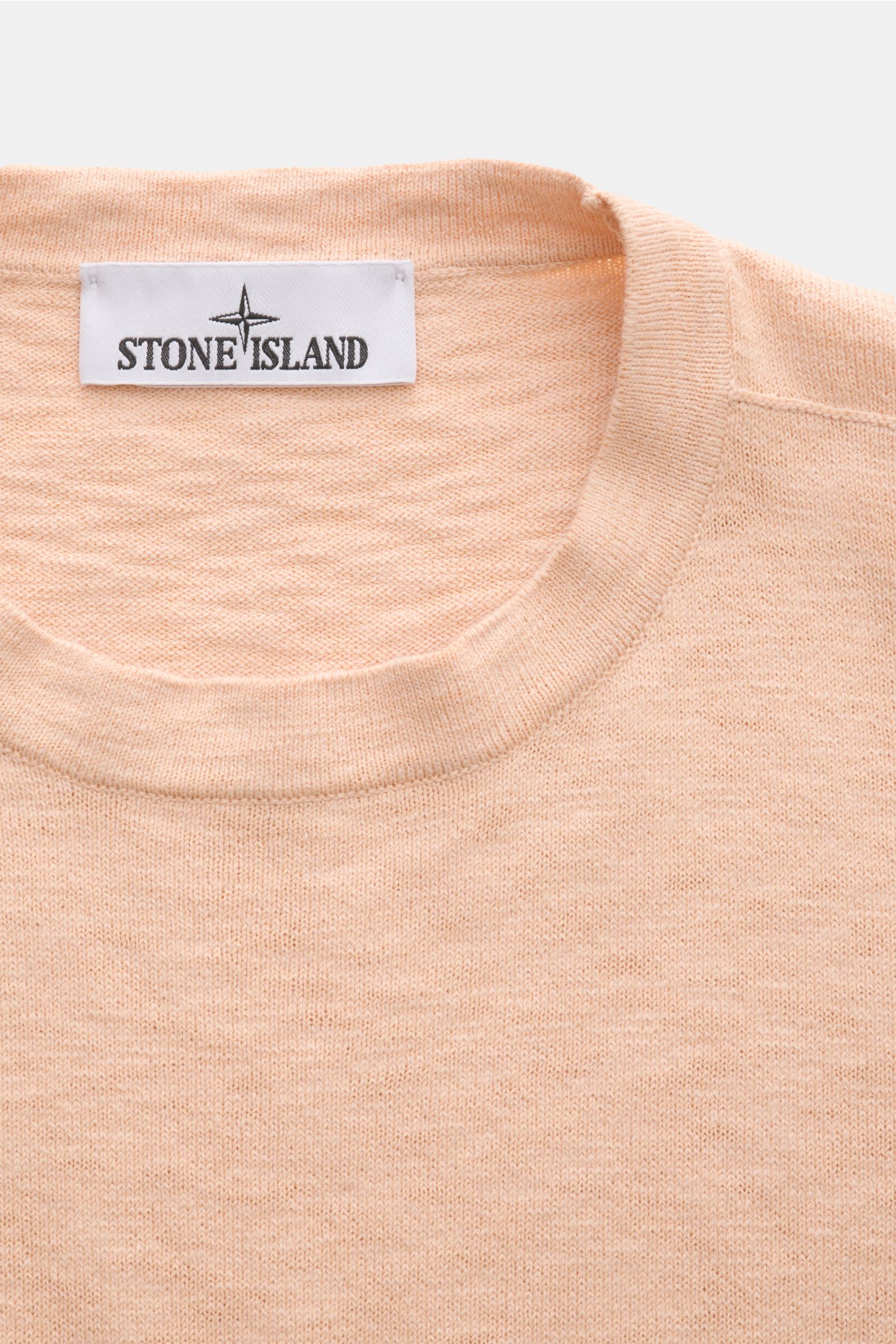 Stone Island Crew neck jumper apricot shown from a top-front close-up, featuring fine knit, rolled edges, and Stone Island label. STONE ISLAND has transformed this crew neck jumper into a sophisticated basic with fine details like the rolled hem and strat