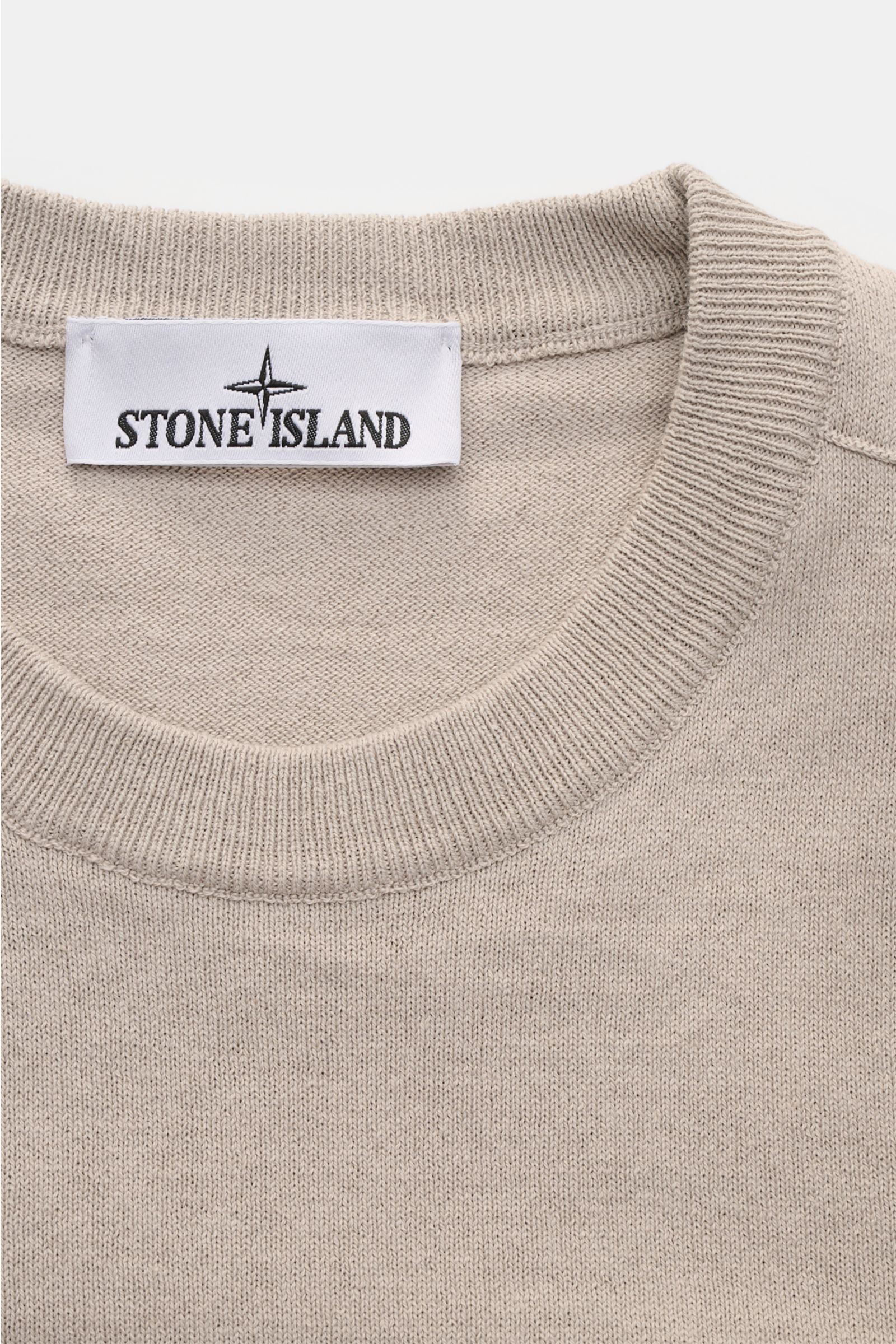 Close-up front view of Stone Island Crew neck jumper light grey showing fine knit texture and ribbed crew neck with label.

STONE ISLAND has transformed this crew neck jumper into a sophisticated basic with fine details like the rolled hem and with pur