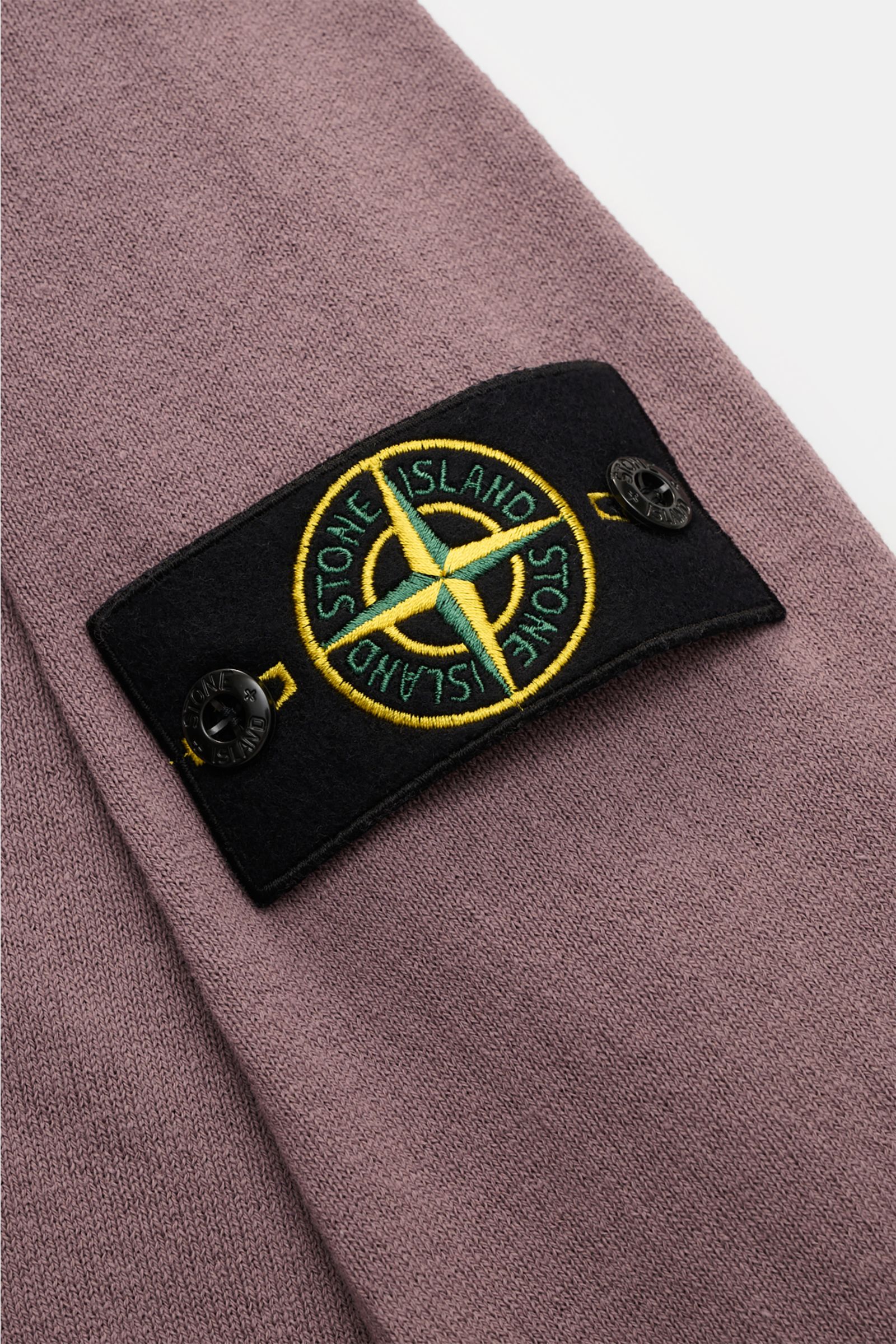Stone Island Rundhalspullover flieder in Slim Fit, aus reiner Baumwolle mit feinem Strickbild, rolliertem Saum, Rundhalsausschnitt und Kompass-Badge, Nahaufnahme.