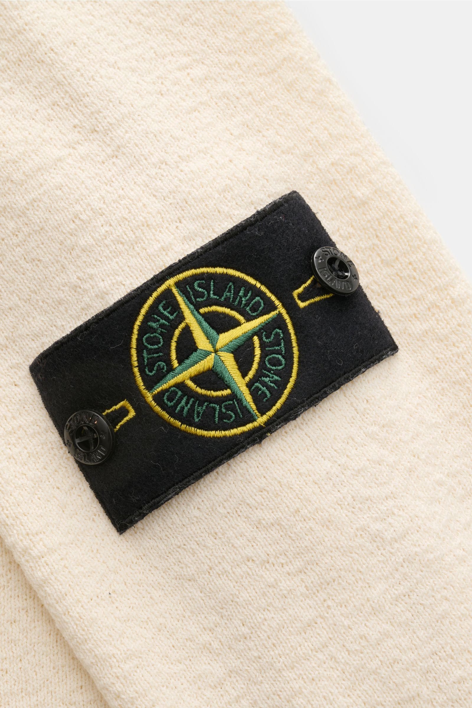 Stone Island Rundhalspullover creme aus leichtem Baumwollstrick mit crincle-Optik, Logo-Badge am Ärmel, Detailaufnahme schräg von oben
