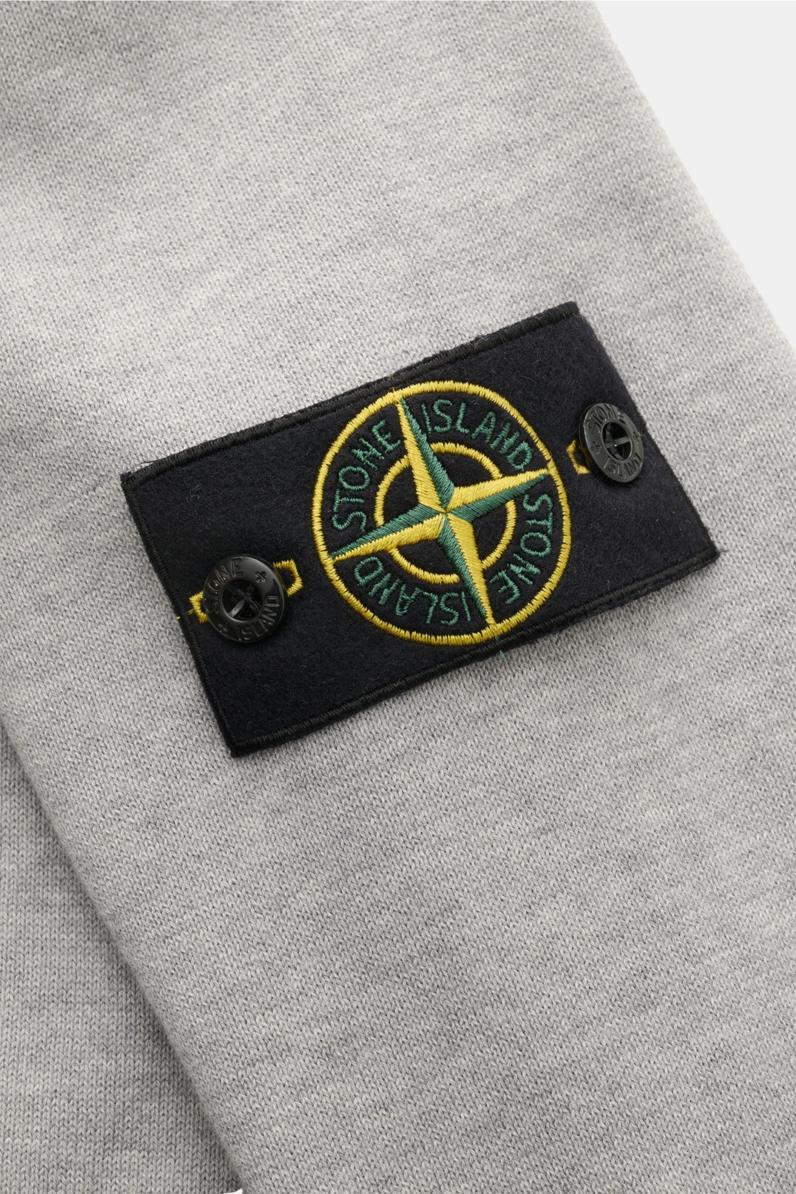 Close-up side view of the Stone Island Crew neck jumper light grey mottled, showing the signature compass badge on the upper sleeve.

Timeless classic: This knitted jumper by STONE ISLAND is a casual spring companion thanks to its comfortable cotton ma