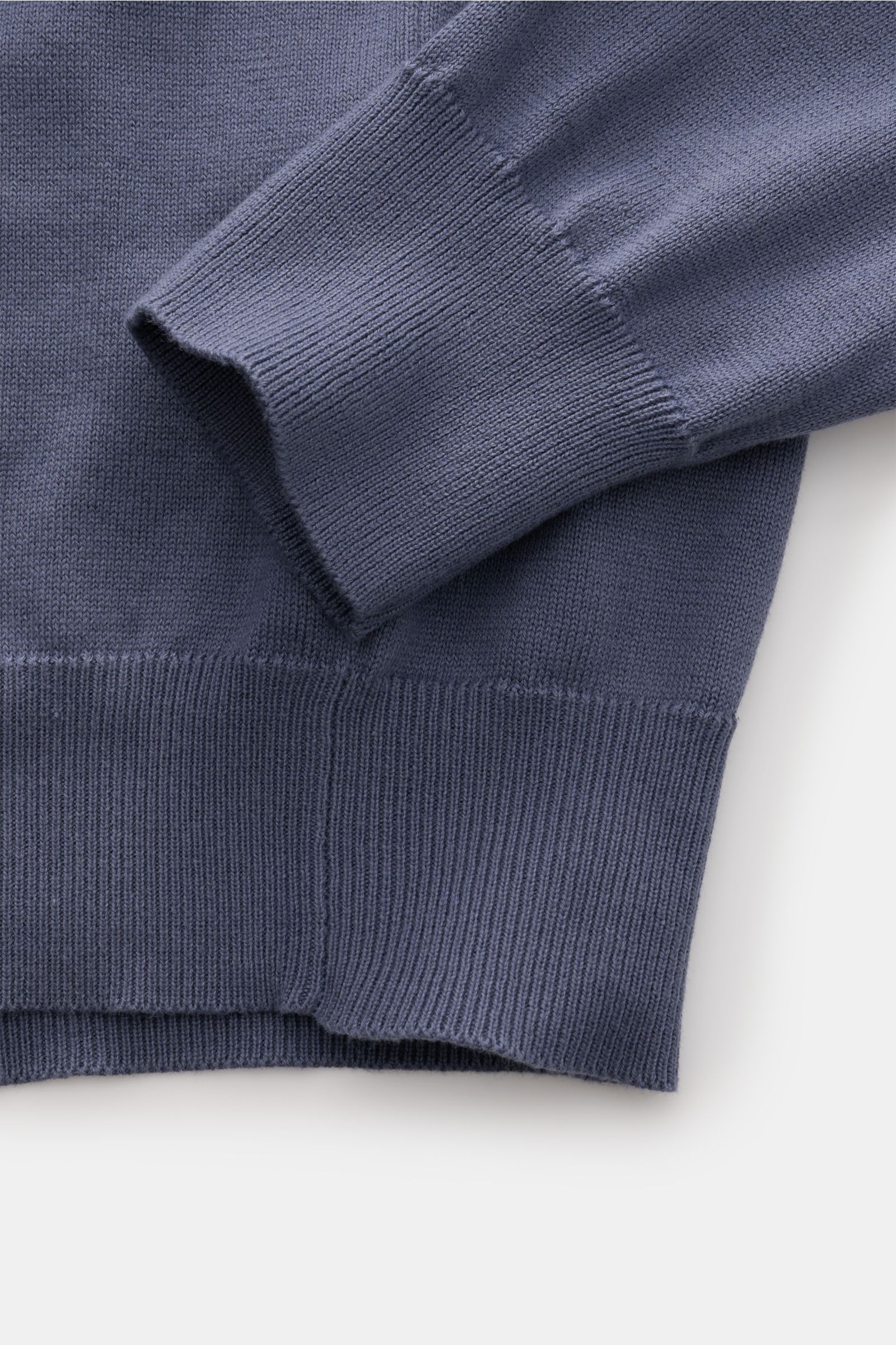 Close-up view of the Stone Island Crew neck jumper smoky blue showing the cuff and hem detailing, highlighting fine knit and ribbed bands.

Description: 
Timeless classic: This knitted jumper by STONE ISLAND is a casual spring companion thanks to its c