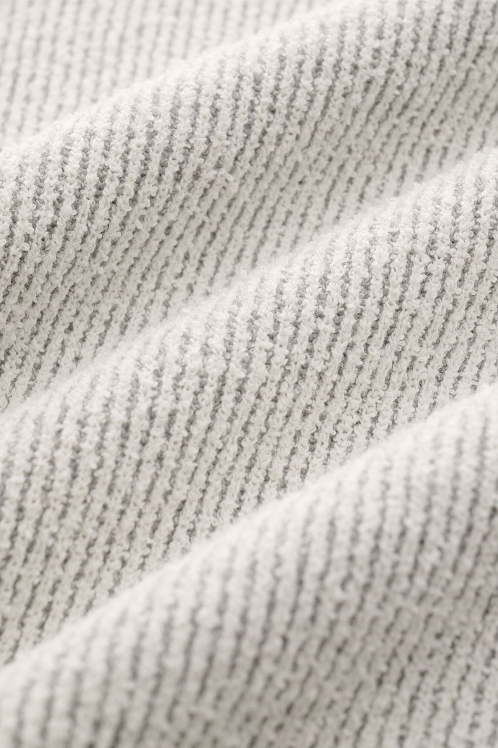 Nahaufnahme der Textur des Stone Island Rundhalspullover offwhite im Rippstrick aus kernigem Loop-Garn, Detailansicht der elastischen und komfortablen Materialstruktur.