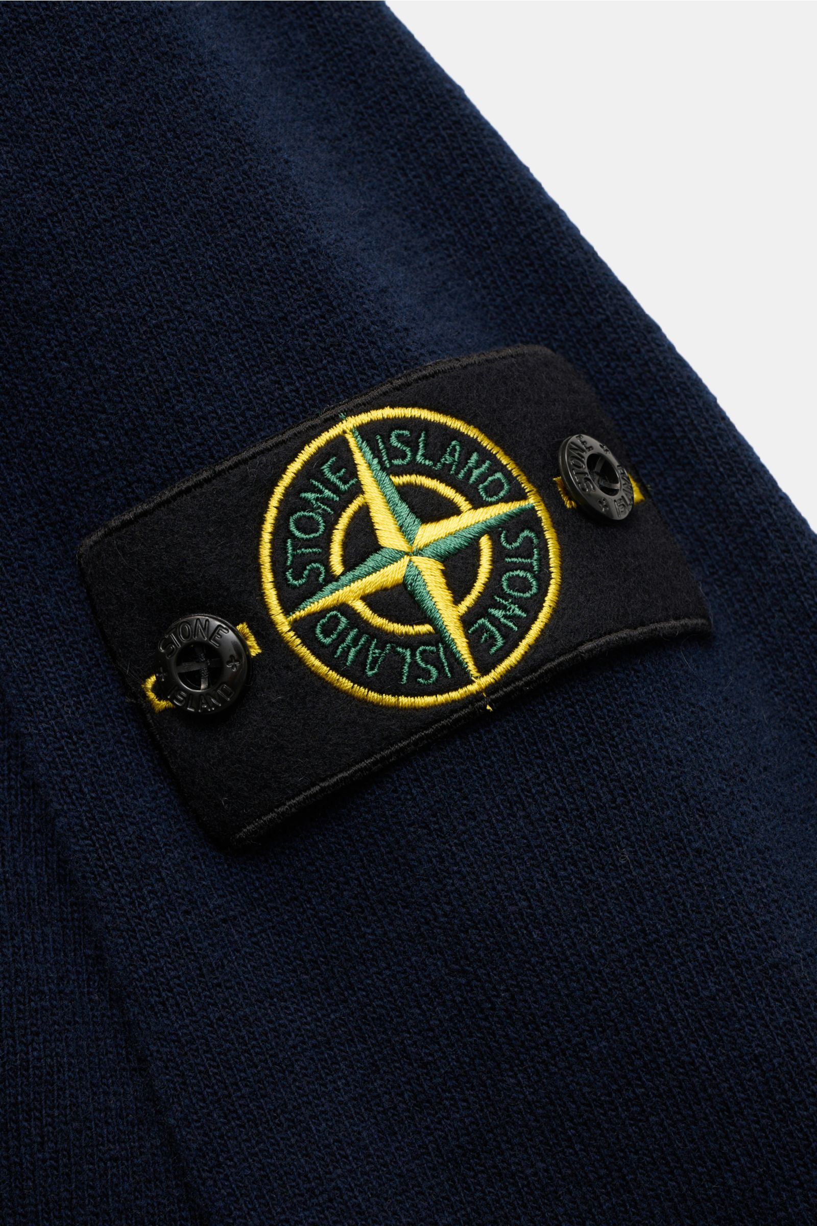 Stone Island Crew neck jumper navy shown in close-up from the side, featuring a tonal compass badge on the upper sleeve. A timeless piece from STONE ISLAND: If you want to create a warm, sporty look, you can’t go wrong with this classic crew neck jumpe