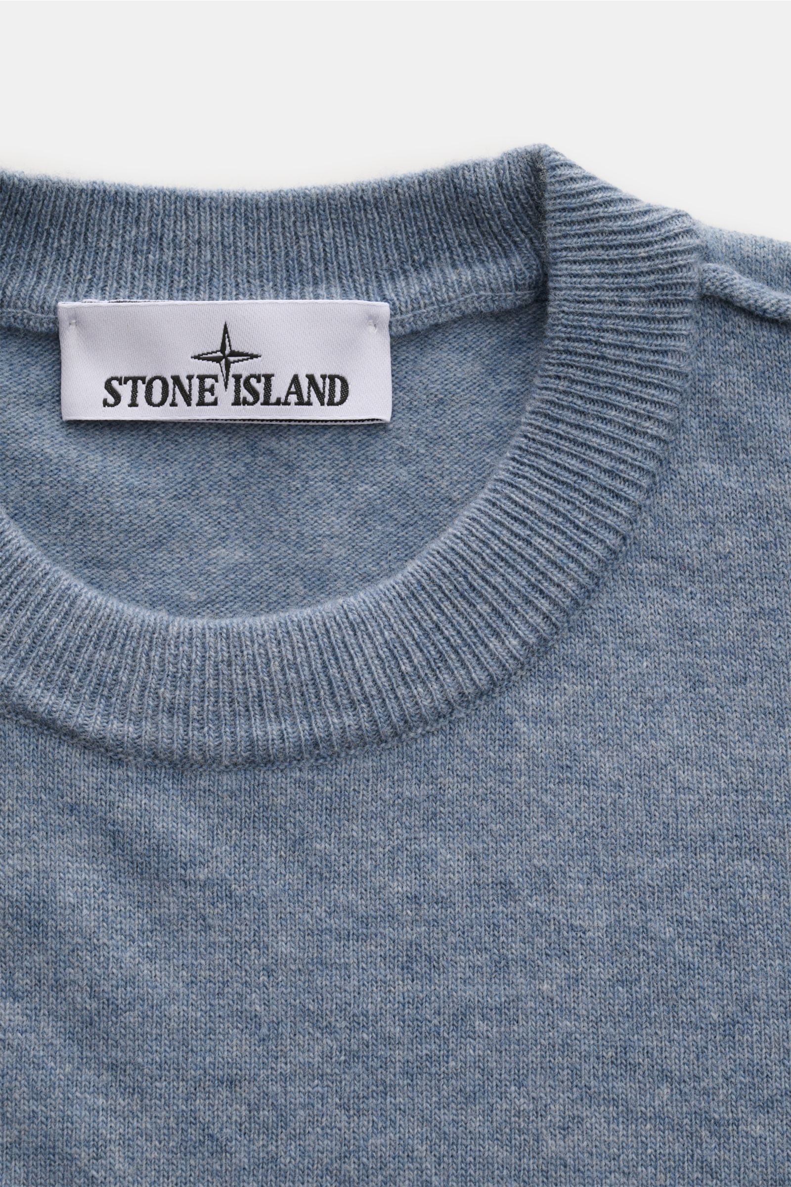 Stone Island Rundhalspullover rauchblau aus reiner Wolle, weicher Griff, feines Strickbild, Regular Fit, Rundhals, elastische Rippbündchen, Detailansicht von oben.