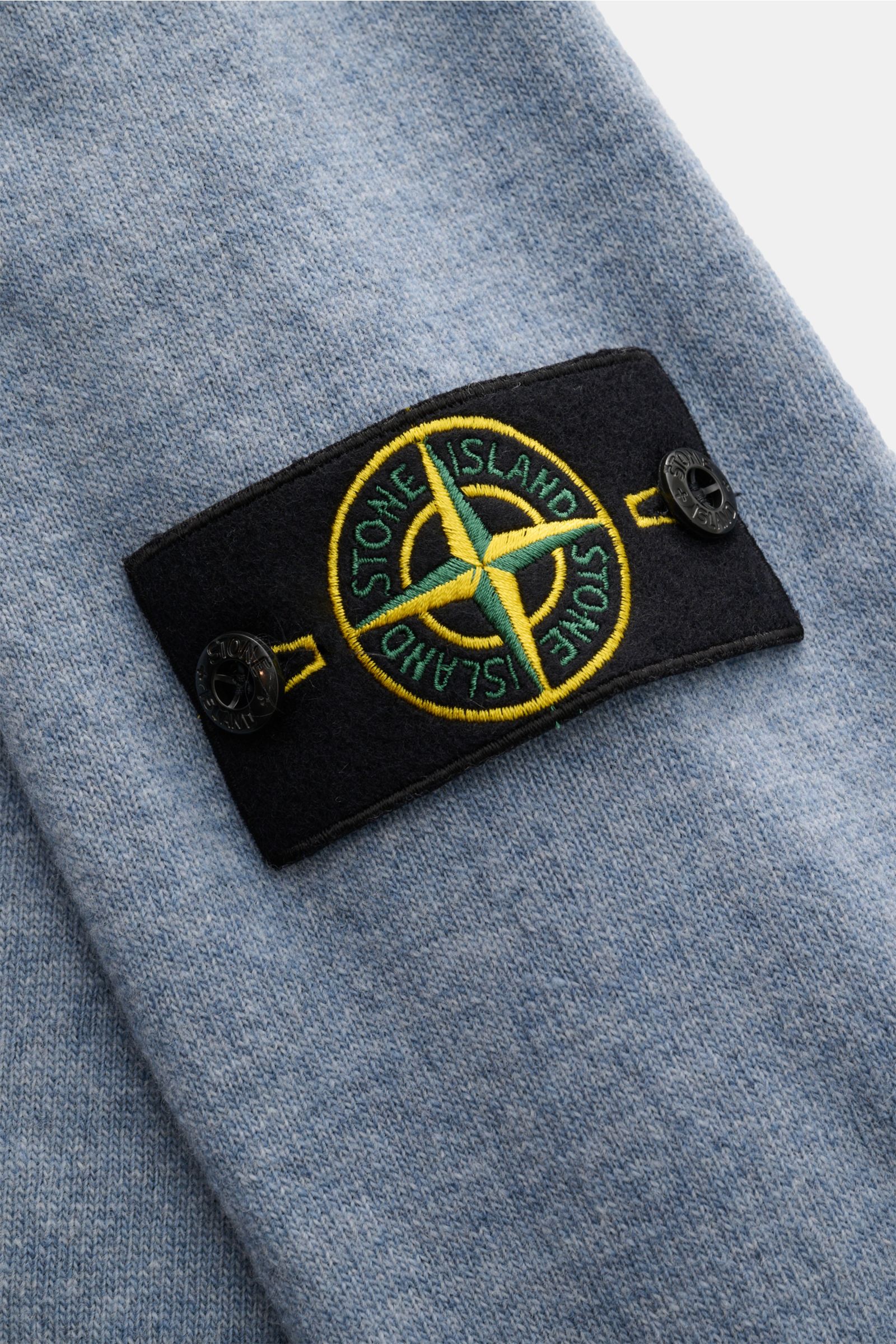 Stone Island Rundhalspullover rauchblau aus reiner Wolle, Detailaufnahme des tonalen Kompass-Badges auf dem Ärmel, weicher Strick.