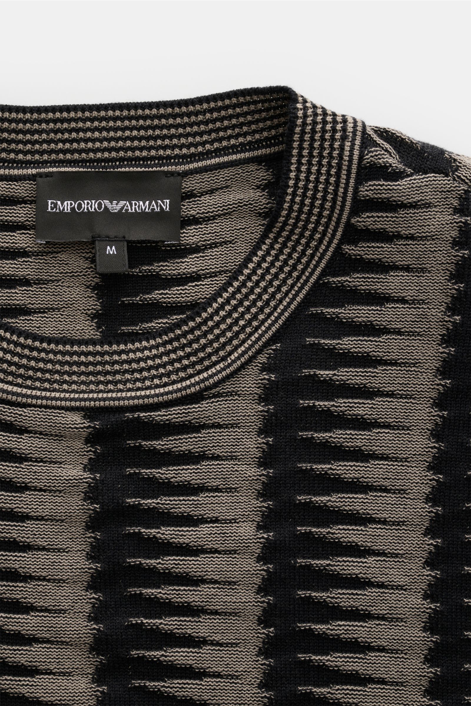 Emporio Armani Rundhalspullover schwarz/grau gemustert, Nahaufnahme von oben, retroeskes Strickmuster, reine Baumwolle, Regular Fit, Rippbündchen, Logo am Saum.