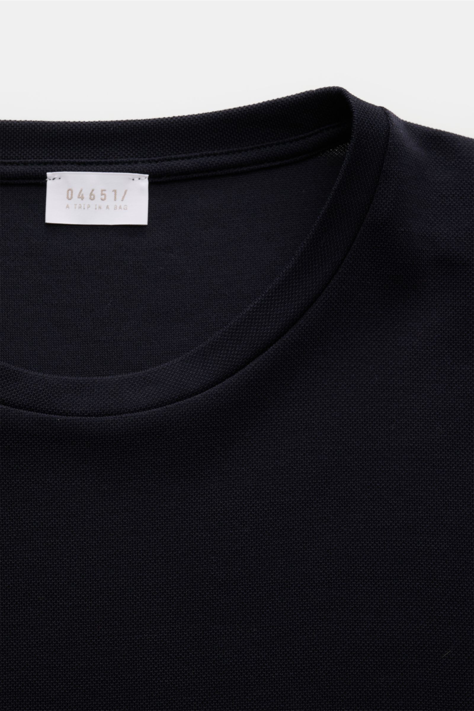 Close-up front view of 04651/ A trip in a bag Rundhals-Longsleeve 'If Tee' navy showing round neckline and label. Das unkomplizierte 'IF Tee' Longsleeve von 04651/ A TRIP IN A BAG ist als Basic aus der neuen Saison nicht wegzudenken und lässt uns in de