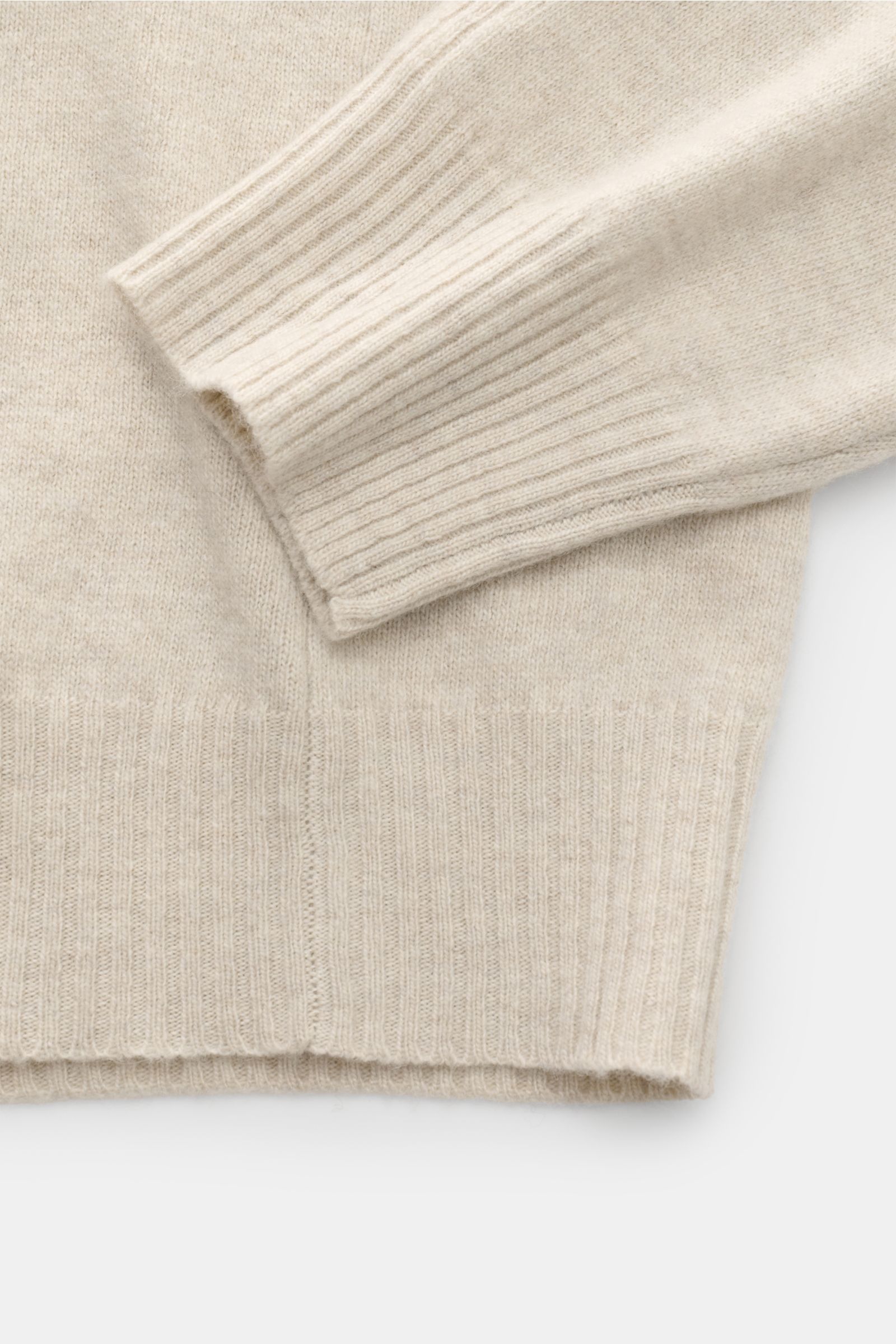 Close-up image of the sleeve and hem of the 04651/ A trip in a bag Crew neck jumper 'Boiled Crew' sand, photographed from above to show its fine knit, slim fit, soft feel, and flexible ribbed bands. Stylish comfort for cold days: This crew neck jumper by 