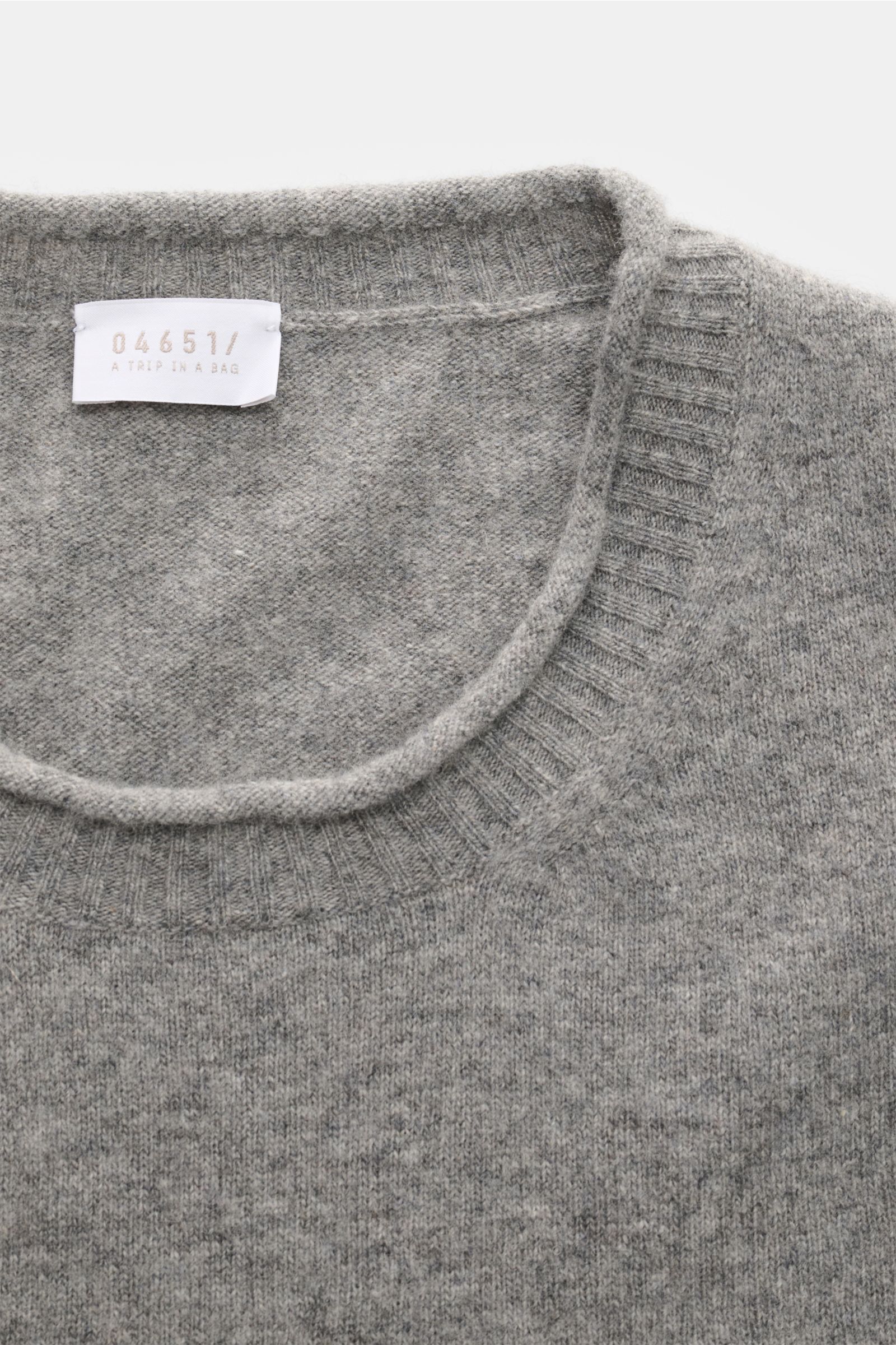 Close-up top-down view of the 04651/ A trip in a bag Crew neck jumper 'Boiled Crew' grey mottled showing the fine knit crew neck with flexible ribbed bands. Stylish comfort for cold days: This jumper by 04651/ A TRIP IN A BAG is a versatile piece with tim