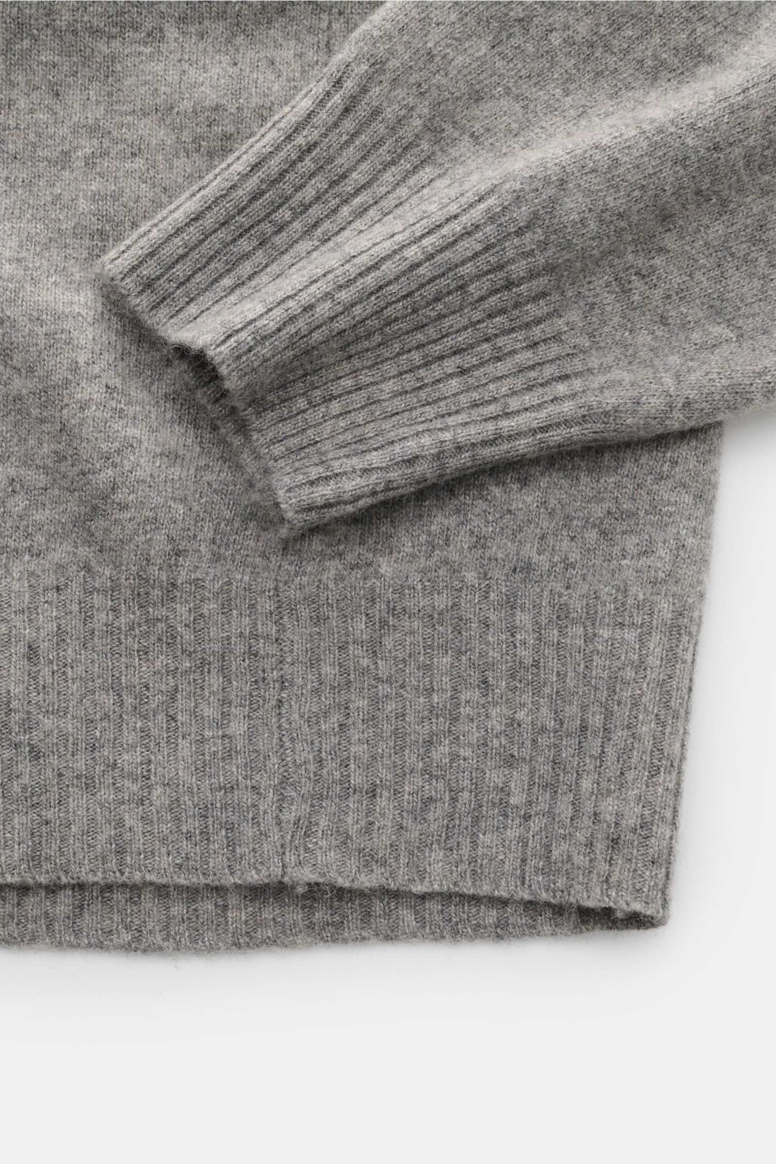 Close-up top-down view of the sleeve and hem of the 04651/ A trip in a bag Crew neck jumper 'Boiled Crew' grey mottled, showing fine knit and flexible ribbed bands. Stylish comfort for cold days: This crew neck jumper by 04651/ A TRIP IN A BAG is a versat
