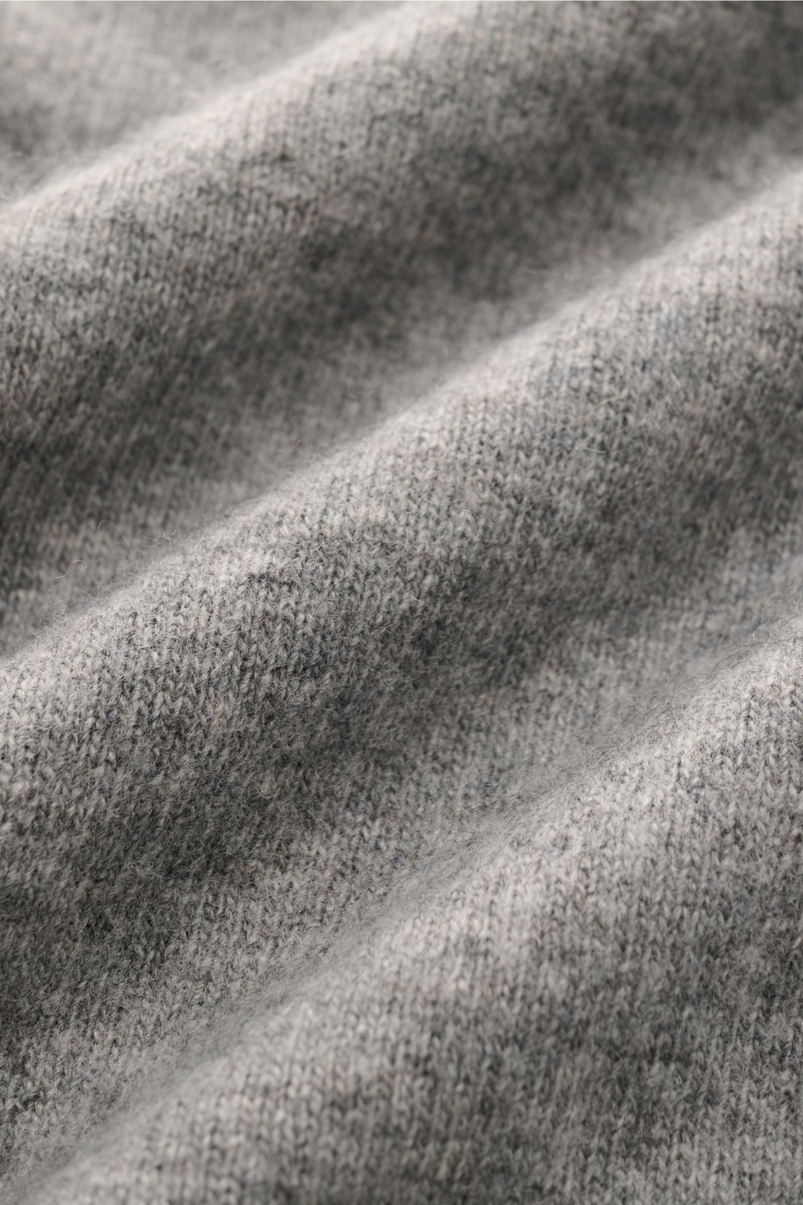 Close-up texture detail of 04651/ A trip in a bag Crew neck jumper 'Boiled Crew' grey mottled fabric, photographed from above, showing fine knit and soft wool-viscose blend. Stylish comfort for cold days: This crew neck jumper by 04651/ A TRIP IN A BAG is
