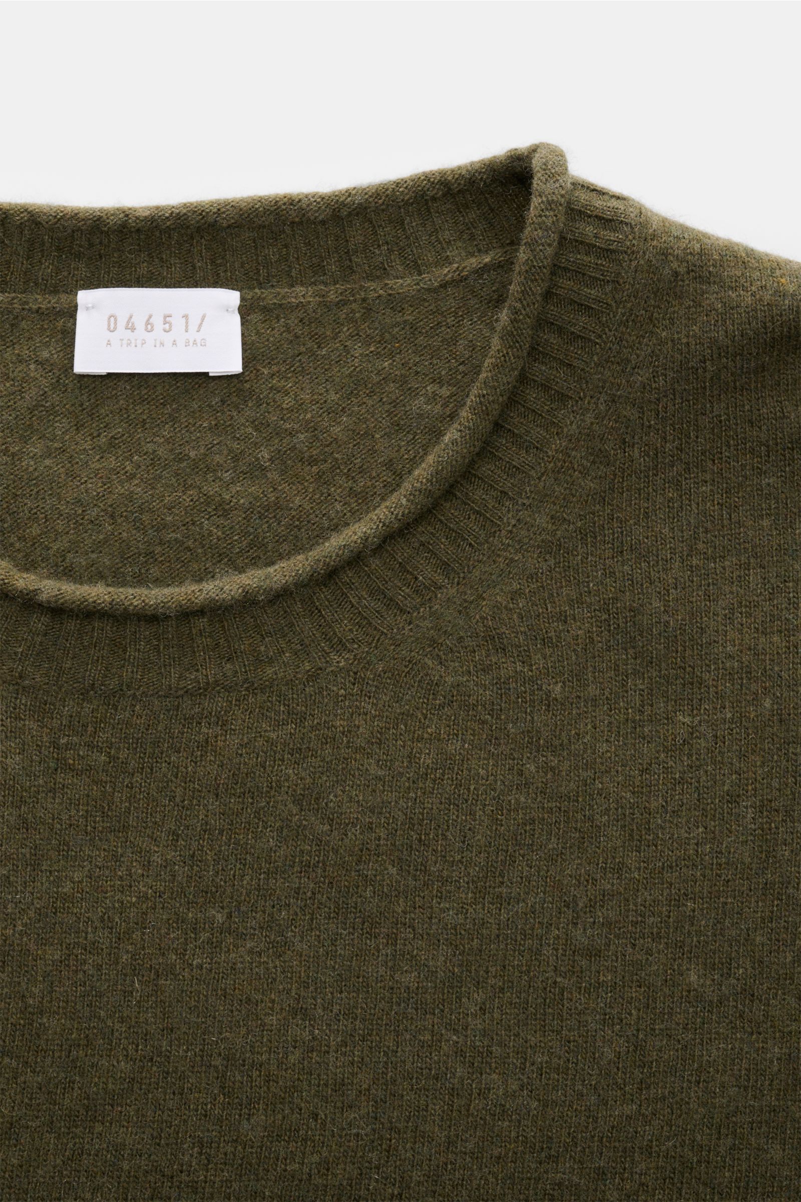 Close-up front view of the olive 04651/ A trip in a bag Crew neck jumper 'Boiled Crew' showing fine knit texture and ribbed crew neck. Stylish comfort for cold days: This crew neck jumper by 04651/ A TRIP IN A BAG is a versatile piece with timeless elegan