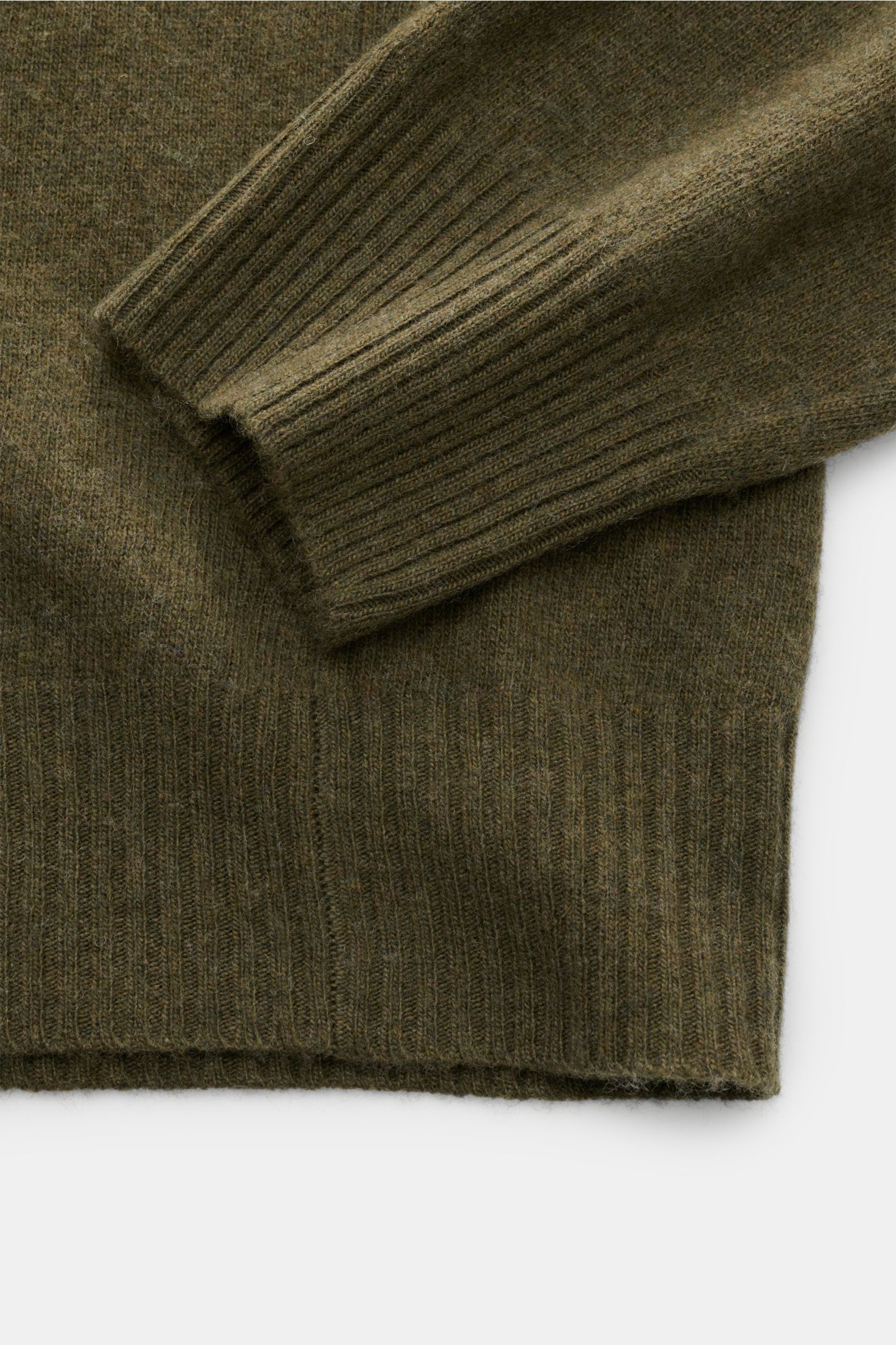 Close-up image from above of the sleeve and hem of the 04651/ A trip in a bag Crew neck jumper 'Boiled Crew' olive, showing its fine knit and flexible ribbed bands in a soft wool and viscose blend. Stylish comfort for cold days: This crew neck jumper by 0