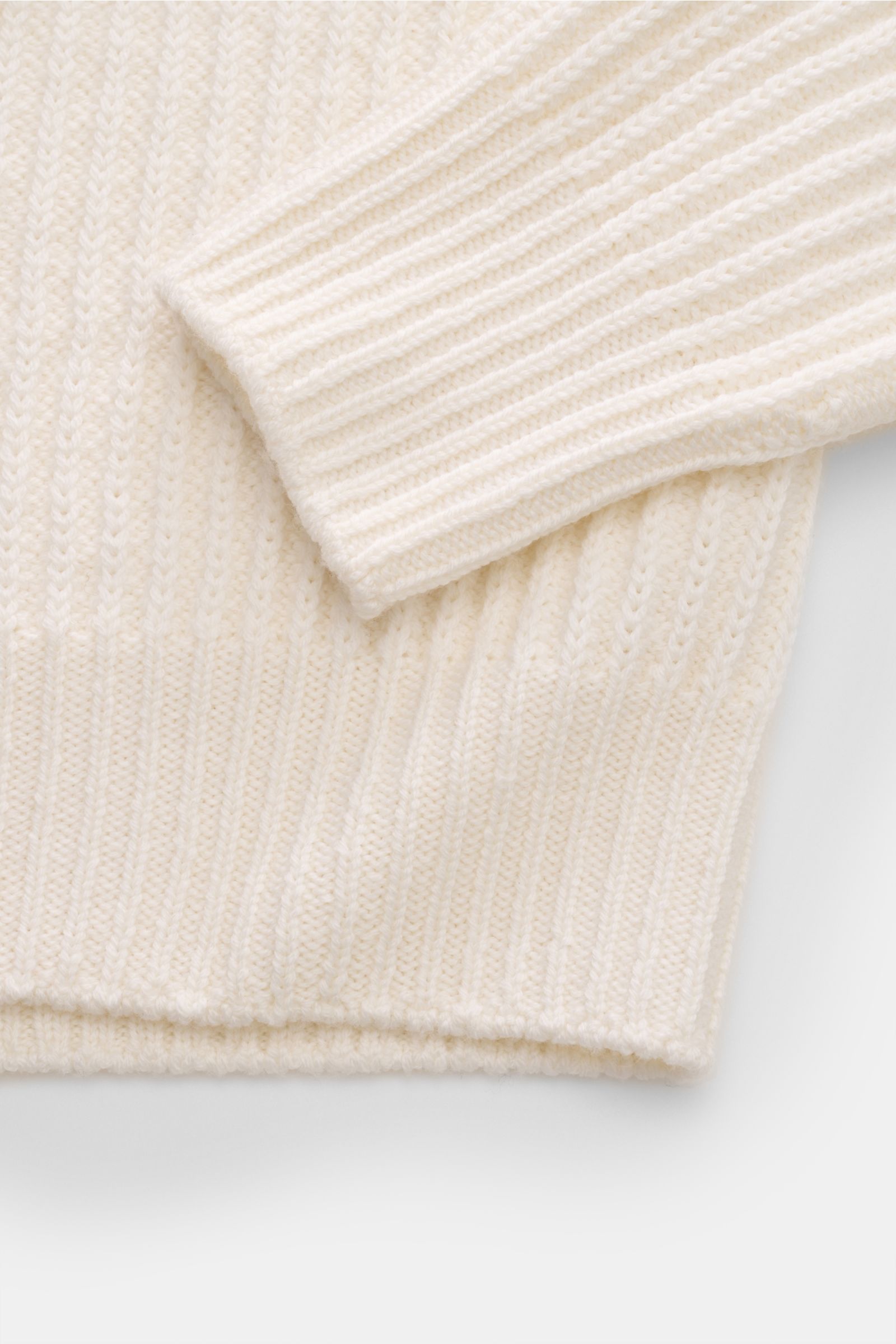 Close-up front view of the offwhite 04651/ A trip in a bag Mock Neck Pullover 'Foggy Mock' showing the sleeve and hem with a grobes Rippstrickmuster. Hochwertiger Tragekomfort mit lässigem Stil – der vielseitig kombinierbare Strickpullover 'Foggy Mock' vo