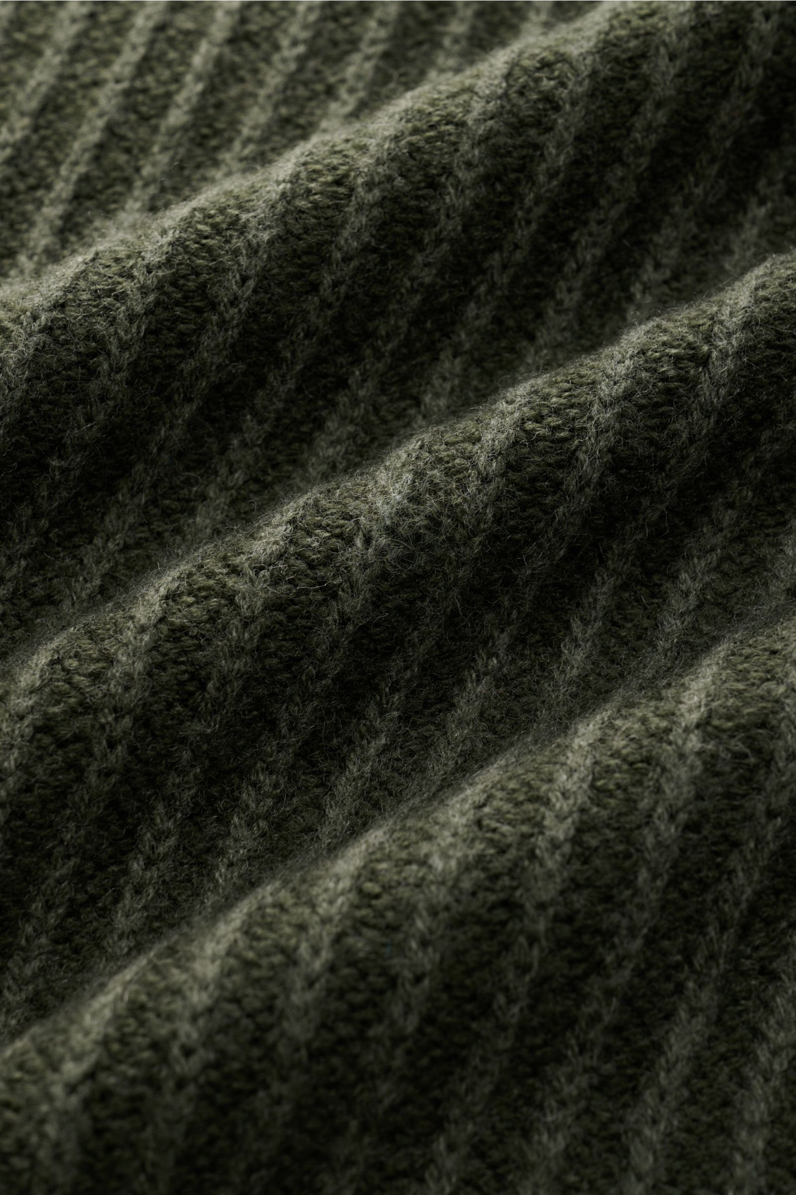 Close-up, angled view of the ribbed knit fabric of the 04651/ A trip in a bag Mock Neck Pullover 'Foggy Mock' dunkelgrün in dark green.

Description: Hochwertiger Tragekomfort mit lässigem Stil – der vielseitig kombinierbare Strickpullover 'Foggy Mock'