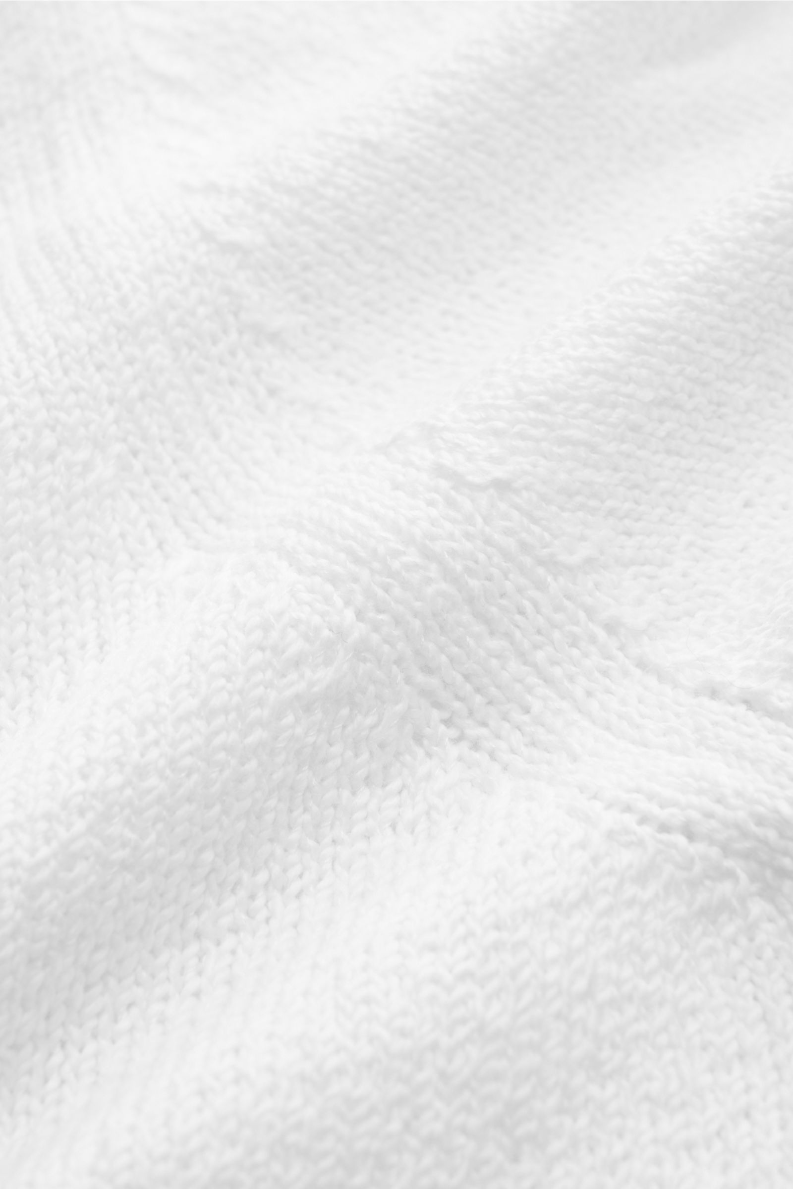 Fioroni Rundhalspullover weiß aus reiner Baumwolle, mittelfeines Strickbild, Slim Fit, weicher Griff, flexible Rippbündchen, Detailfoto aus Nahaufnahme.