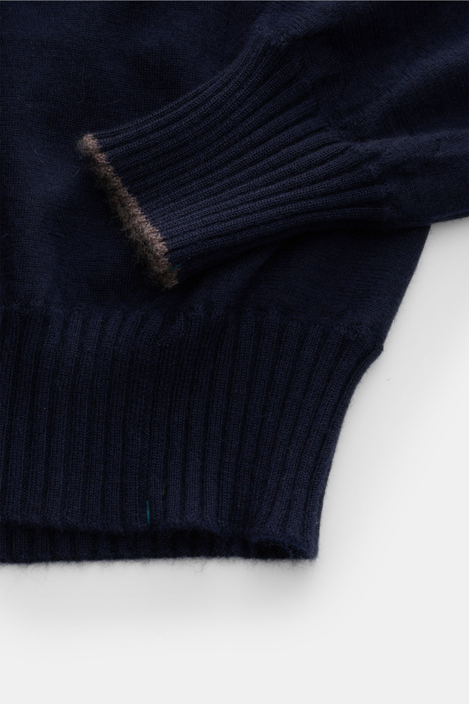 Close-up top-down view of Fioroni Cashmere Rundhalspullover navy showing ribbed cuffs with contrast edges and fine knit texture.

Description: Luxus, den man sofort spürt: Dieser Rundhalspullover von FIORONI verkörpert höchste italienische Strickkunst 