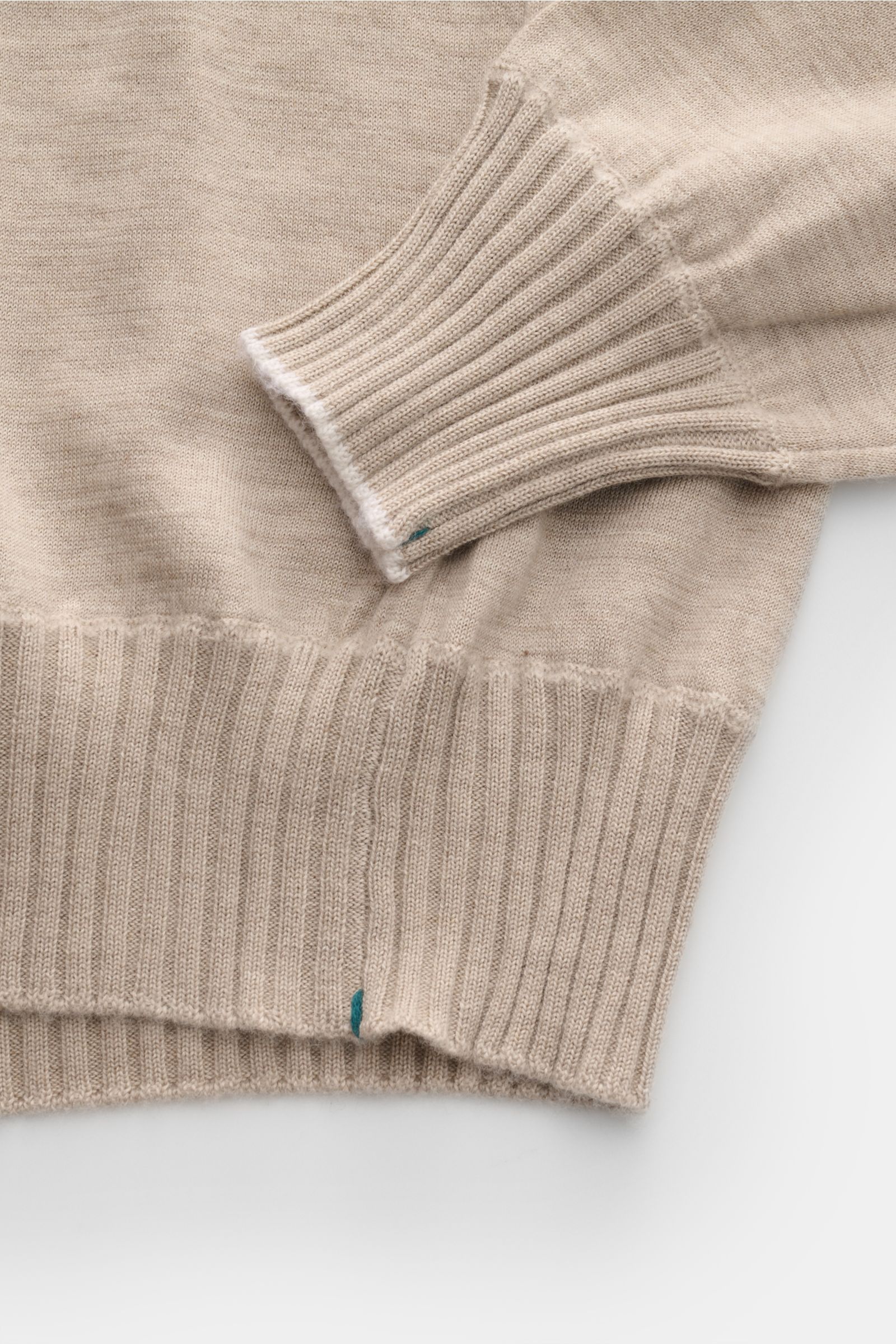 Nahaufnahme des Fioroni Cashmere Rundhalspullover beige meliert von schräg oben, zeigt weichen, feinen Strick mit schmalen Kontrastkanten, Slim Fit und flexible Rippbündchen.