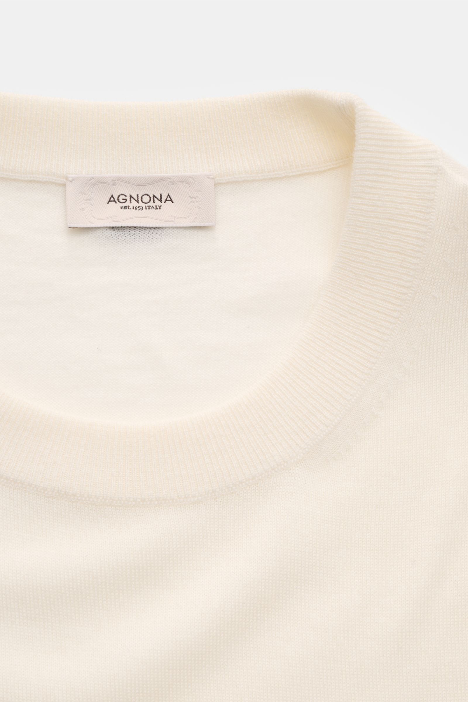 Agnona Cashmere Rundhalspullover creme in Nahaufnahme von oben mit feinem Strickbild, Rundhalsausschnitt, Rippbündchen und AGNONA-Metalllabel.