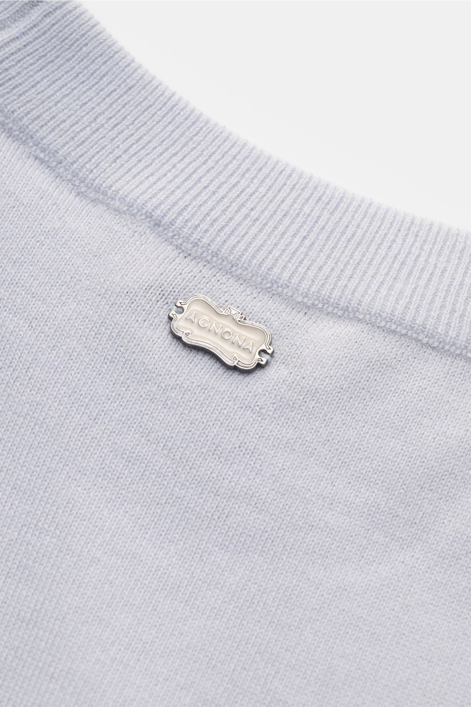 Nahaufnahme des Agnona Cashmere Rundhalspullover rauchblau von oben, zeigt feines Strickbild, Rundhalsausschnitt und AGNONA-Metalllabel.