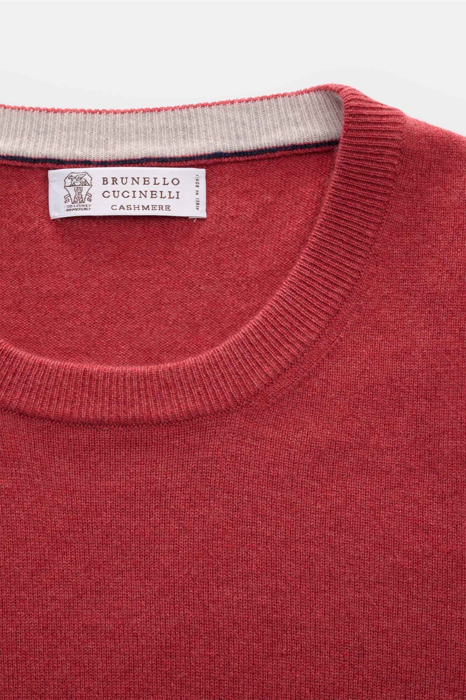 Close-up front view of a Brunello Cucinelli Cashmere Rundhalspullover hellrot, a luxurious light red cashmere crewneck sweater with fine knit, soft touch, narrow contrast edges, and flexible ribbed cuffs. Als vielseitiges Essential bietet dieser luxuri