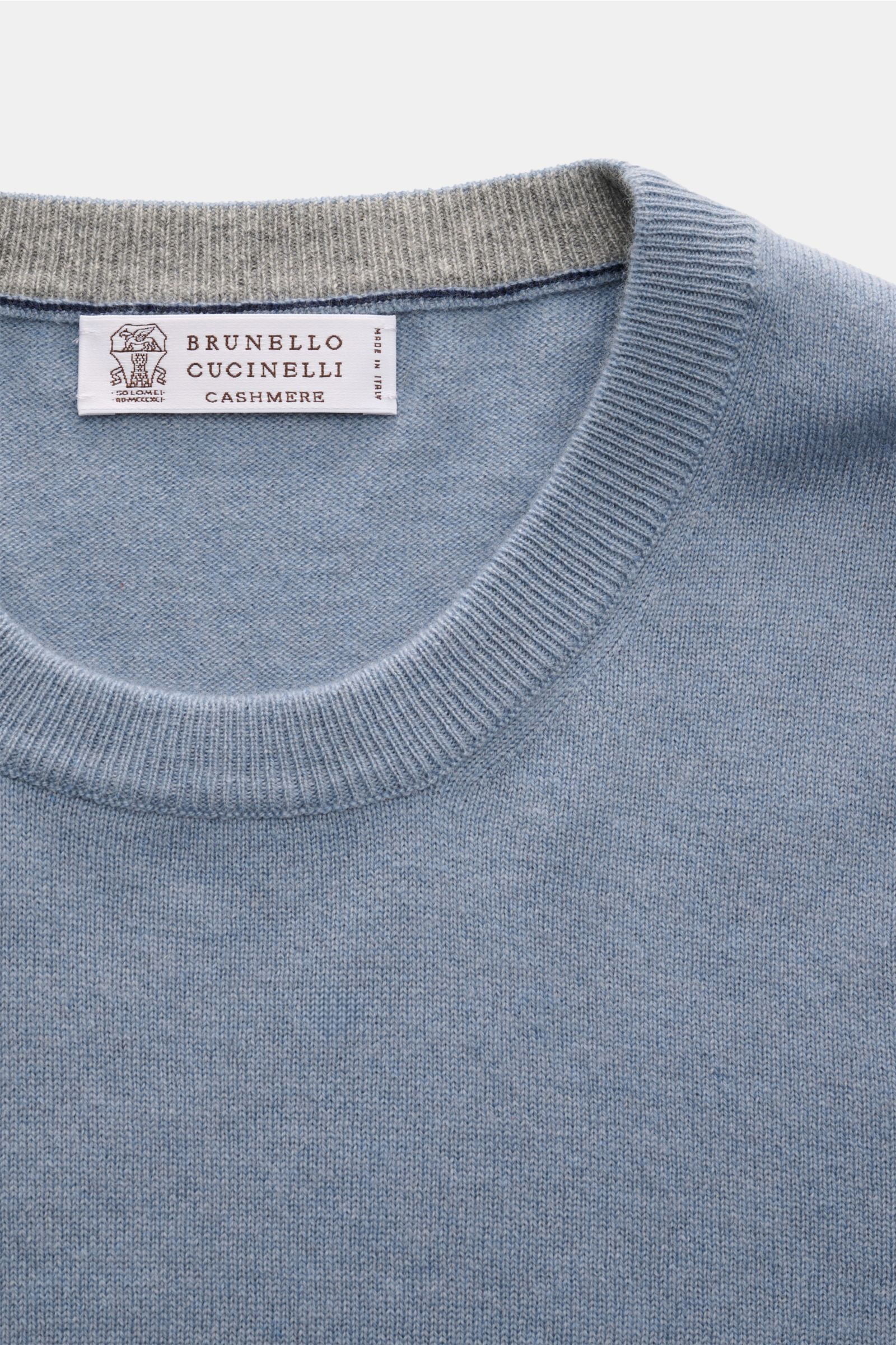 Brunello Cucinelli Cashmere Rundhalspullover rauchblau shown from a top close-up view, highlighting the round neckline and label. Als vielseitiges Essential bietet dieser luxuriöse Cashmerepullover mit Rundhalsausschnitt von BRUNELLO CUCINELLI nicht nu