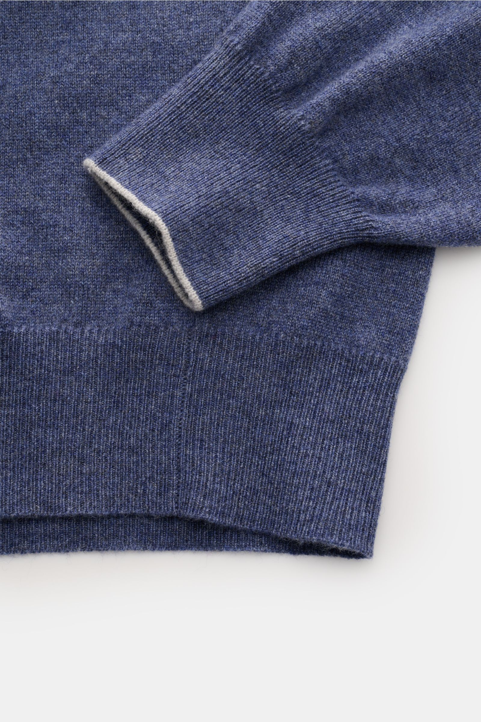 Close-up, top-down view of the sleeve and hem of the Brunello Cucinelli Cashmere Rundhalspullover blau meliert, featuring fine knit, soft texture, narrow contrast edges, and ribbed cuffs.

Als vielseitiges Essential bietet dieser luxuriöse Cashmerepull