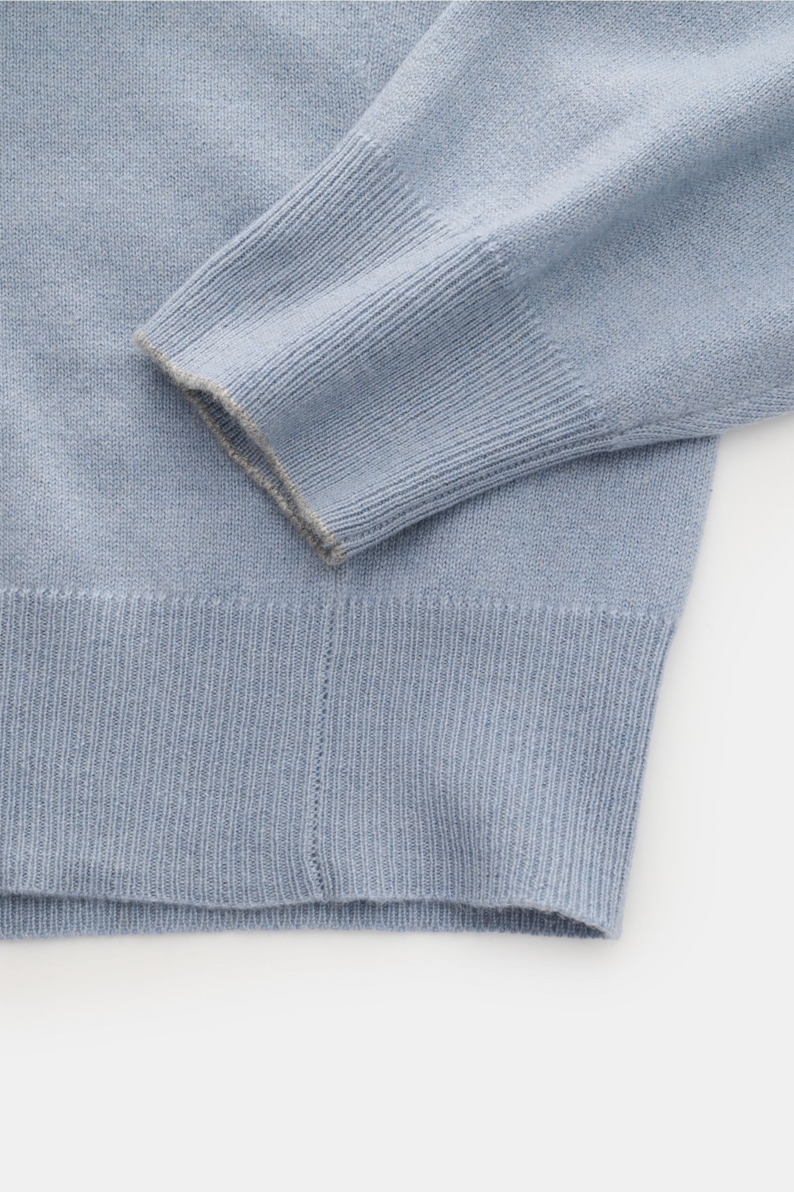 Brunello Cucinelli Cashmere V-Neck Pullover rauchblau, Detailaufnahme von Ärmel und Bund mit schmalen Kontrastkanten, feinem Strickbild, weicher Griff.