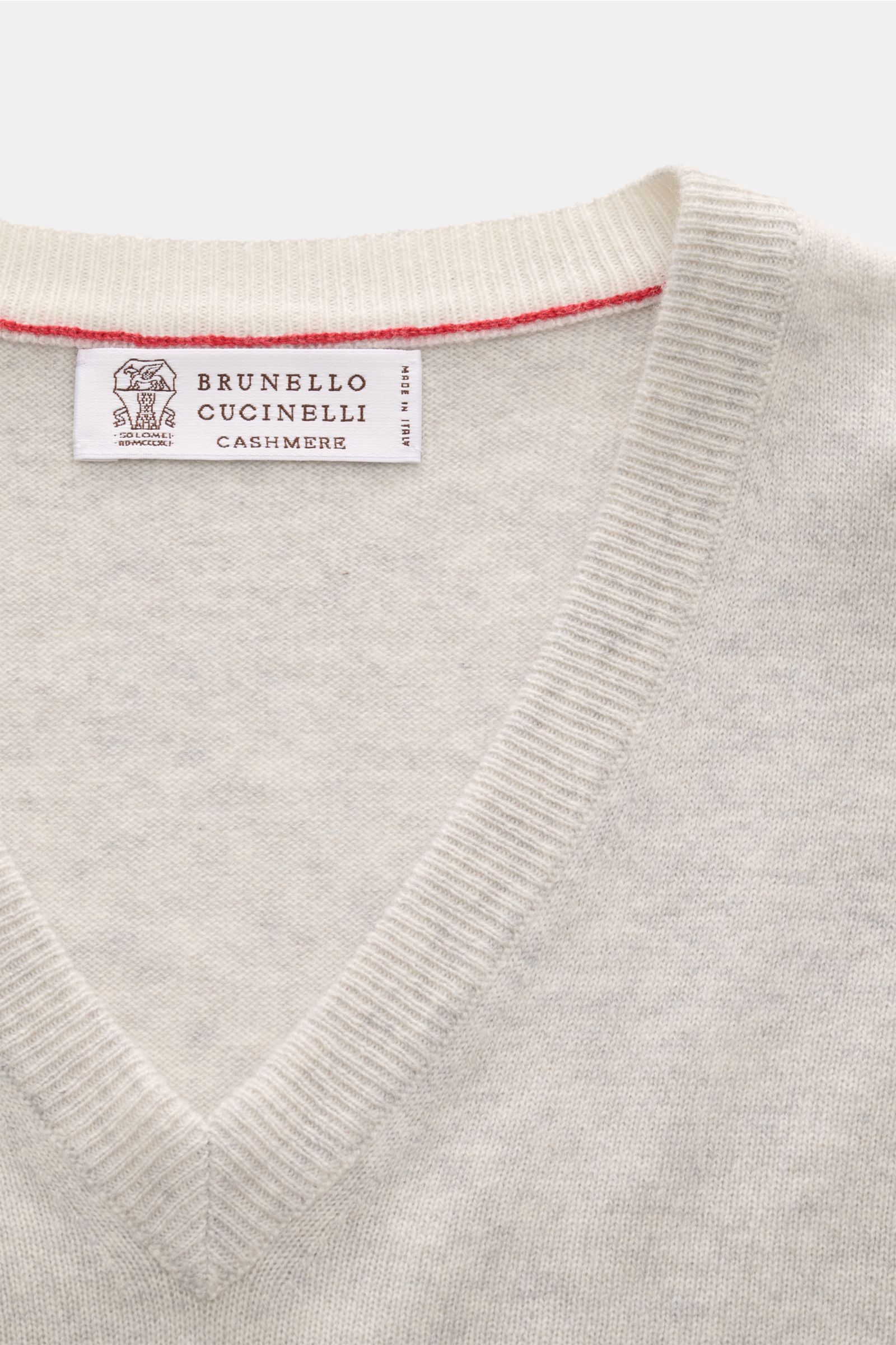 Close-up top-down view of the Brunello Cucinelli Cashmere V-Neck Pullover hellgrau meliert showing its fine knit, soft texture, V-neck, and slim contrast edges. Luxuriöser Cashmere in Verbindung mit klassischem Design: Der V-Neck Pullover mit schmalen Kon