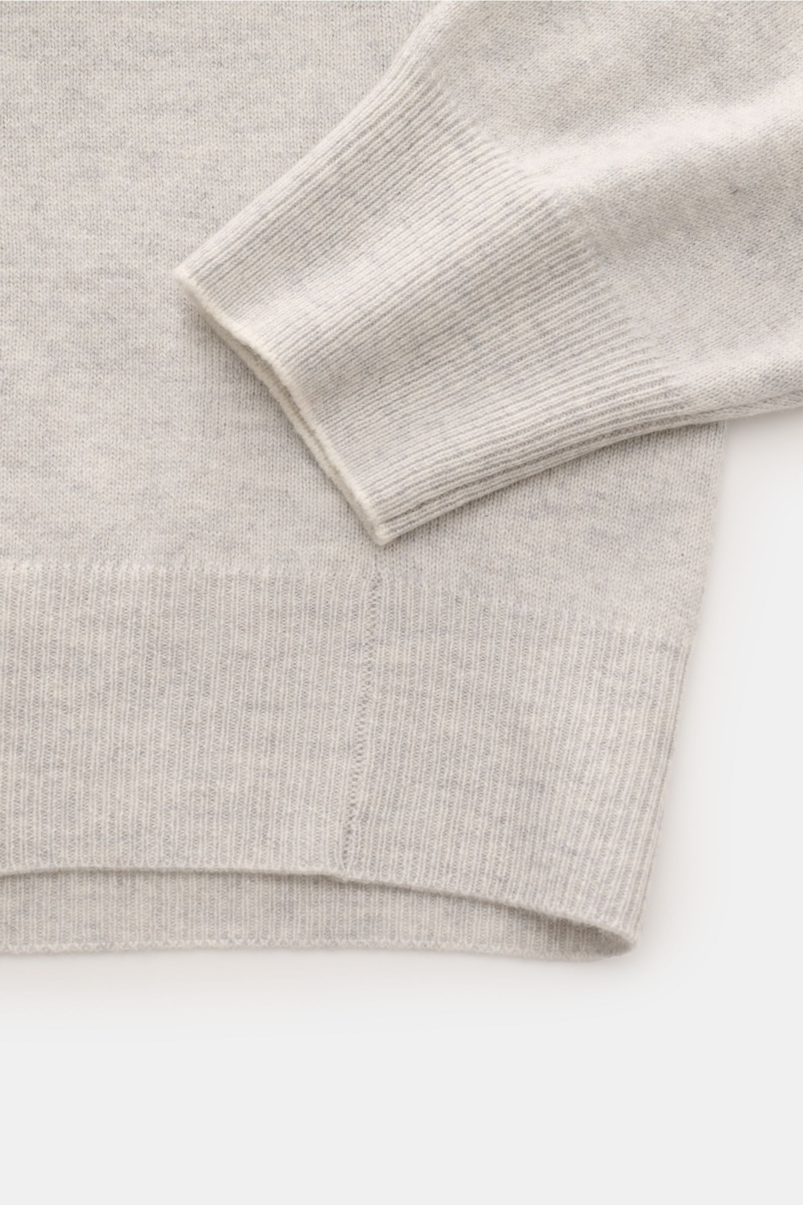 Close-up top-down view of the ribbed cuff and hem of the Brunello Cucinelli Cashmere V-Neck Pullover hellgrau meliert, showcasing fine knit and soft texture. Luxuriöser Cashmere in Verbindung mit klassischem Design: Der V-Neck Pullover mit schmalen Kon