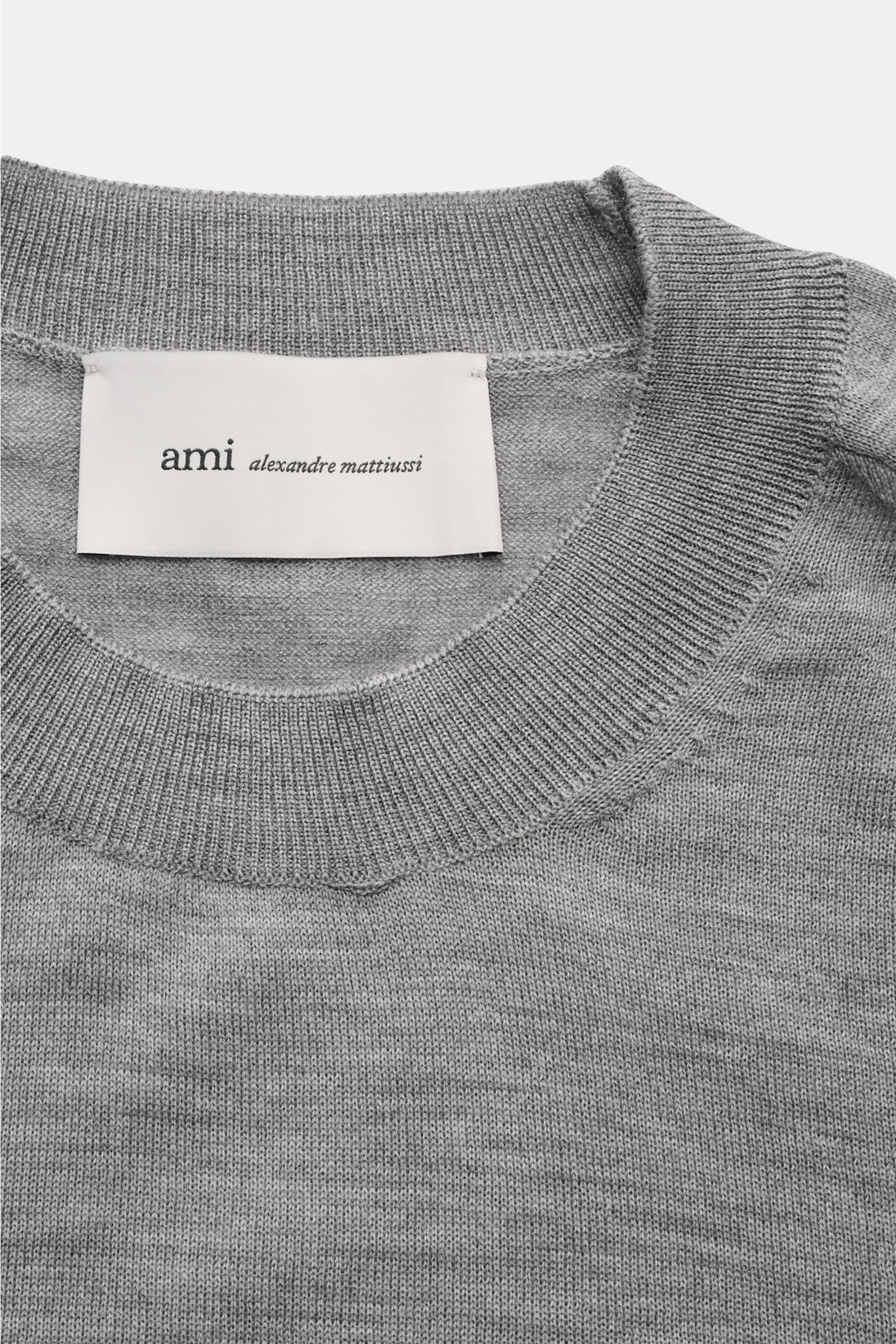 Ami Paris Merino Rundhalspullover grau meliert, Nahaufnahme von Rundhalsausschnitt und Label, feines Strickbild, weicher Griff, Regular Fit, Rippbündchen, reine Merinowolle, Logo-Stitching auf der Brust.
