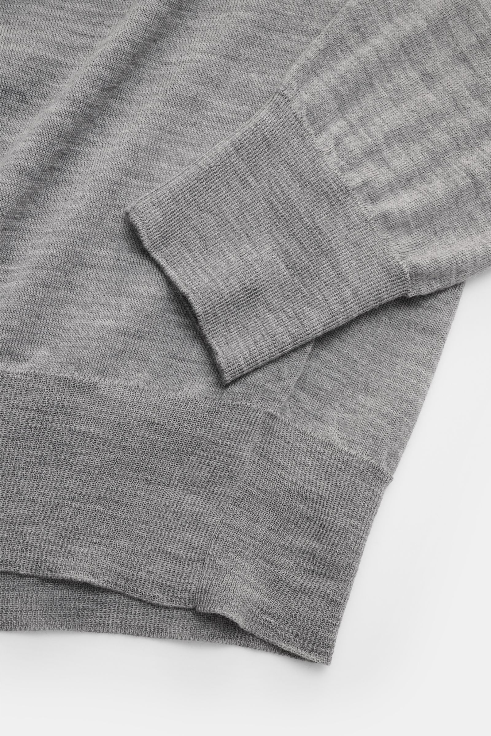 Ausschnitt von Ärmel und Saum des Ami Paris Merino Rundhalspullover grau meliert, aus reiner Merinowolle mit feinem Strickbild, weichem Griff, Regular Fit, Rundhalsausschnitt, Logo-Stitching auf der Brust und komfortablen Rippbündchen, frontal fotografier