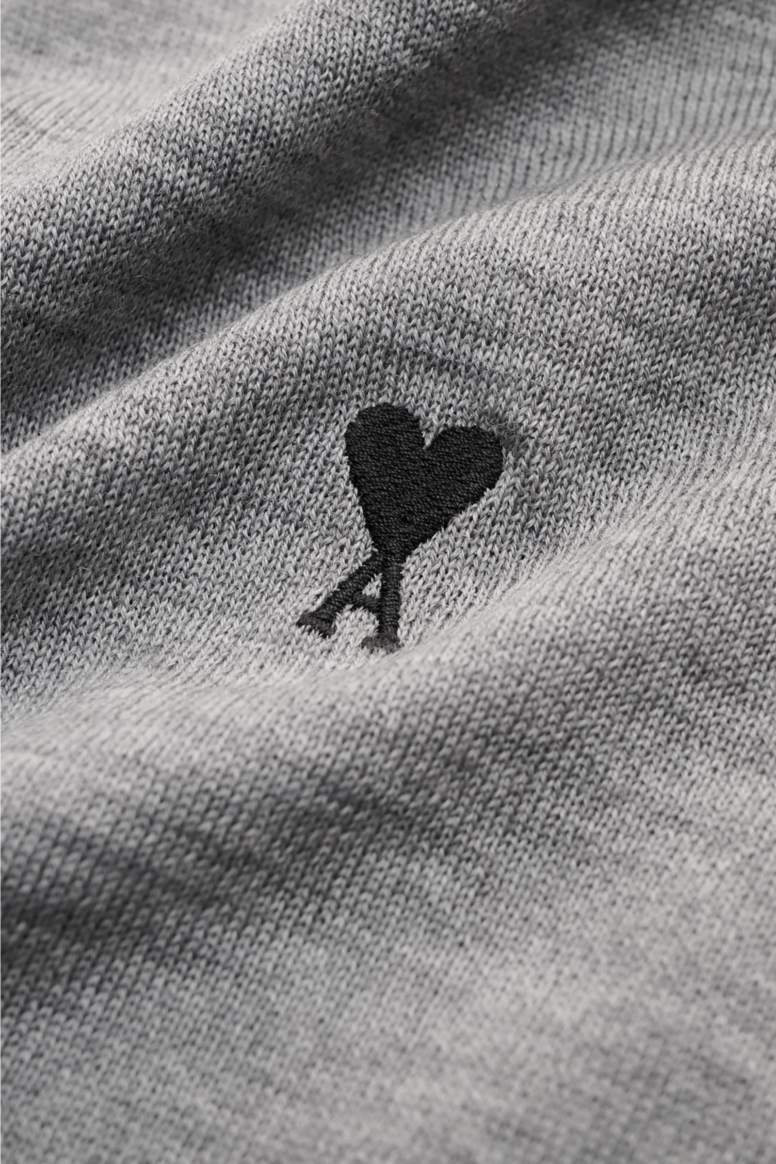 Nahaufnahme des Ami Paris Merino Rundhalspullover grau meliert, zeigt feines Strickbild, Logo-Stitching auf der Brust und weichen Griff aus reiner Merinowolle.