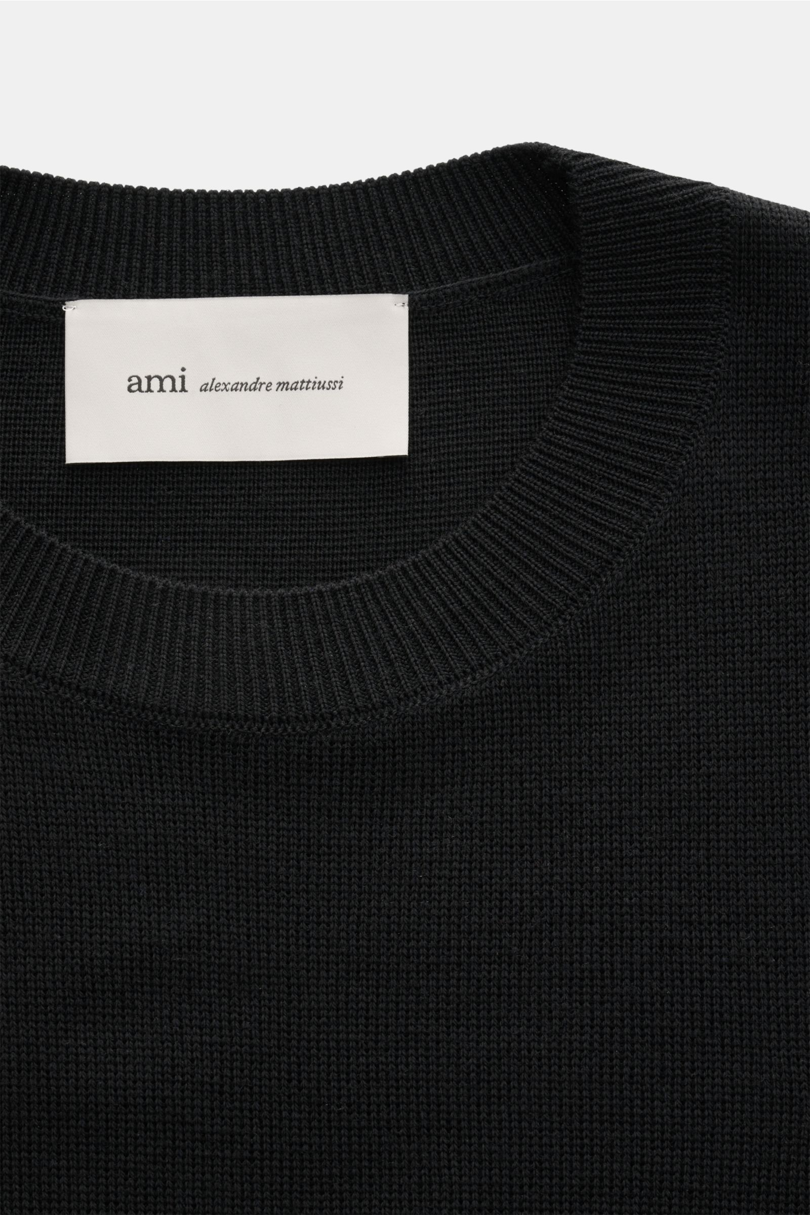 Ami Paris Merino Rundhalspullover schwarz, Detailaufnahme von oben, reine Merinowolle, feines Strickbild, Regular Fit, Rundhalsausschnitt, weicher Griff, Logo-Stitching, komfortable Rippbündchen.