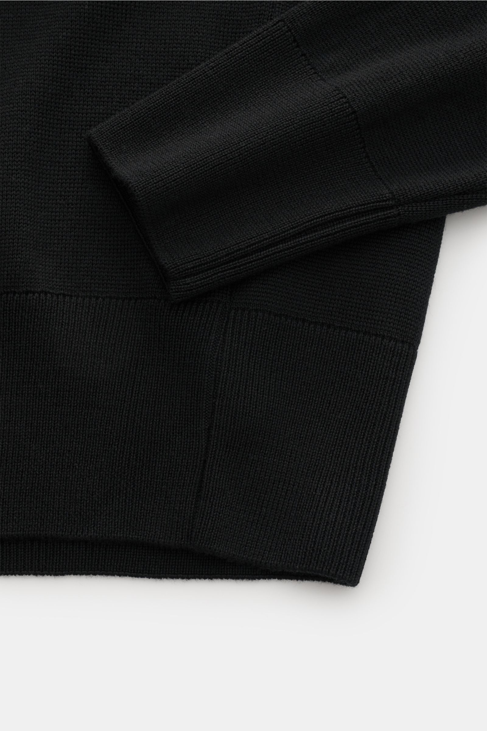 Schwarzer Ami Paris Merino Rundhalspullover in Nahaufnahme von unten, feines Strickbild, Rippbündchen, Logo-Stitching, Regular Fit.