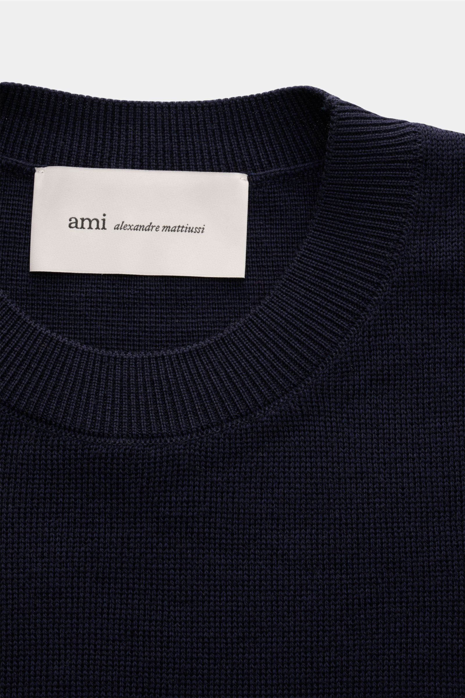 Ami Paris Merino Rundhalspullover navy aus reiner Merinowolle, weicher Griff, feines Strickbild, Regular Fit, Rundhalsausschnitt, Logo-Stitching, Rippbündchen, Nahaufnahme von oben.