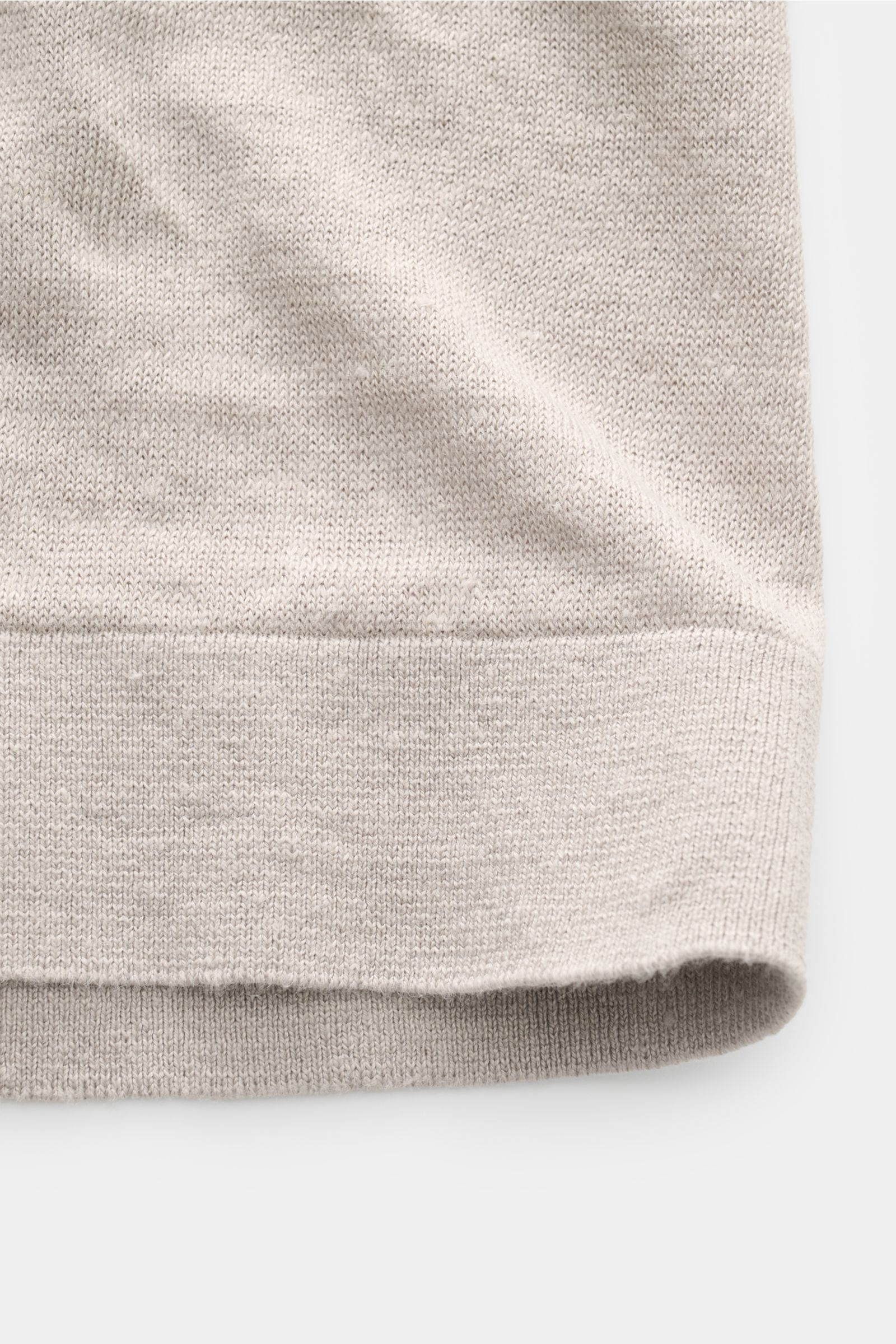 C.P. Company Kurzarmpullover grau in Nahaufnahme von unten, feiner Leinenstrick, weicher Griff, Regular Fit, elastische Rippbündchen, Weblabel am Saum.