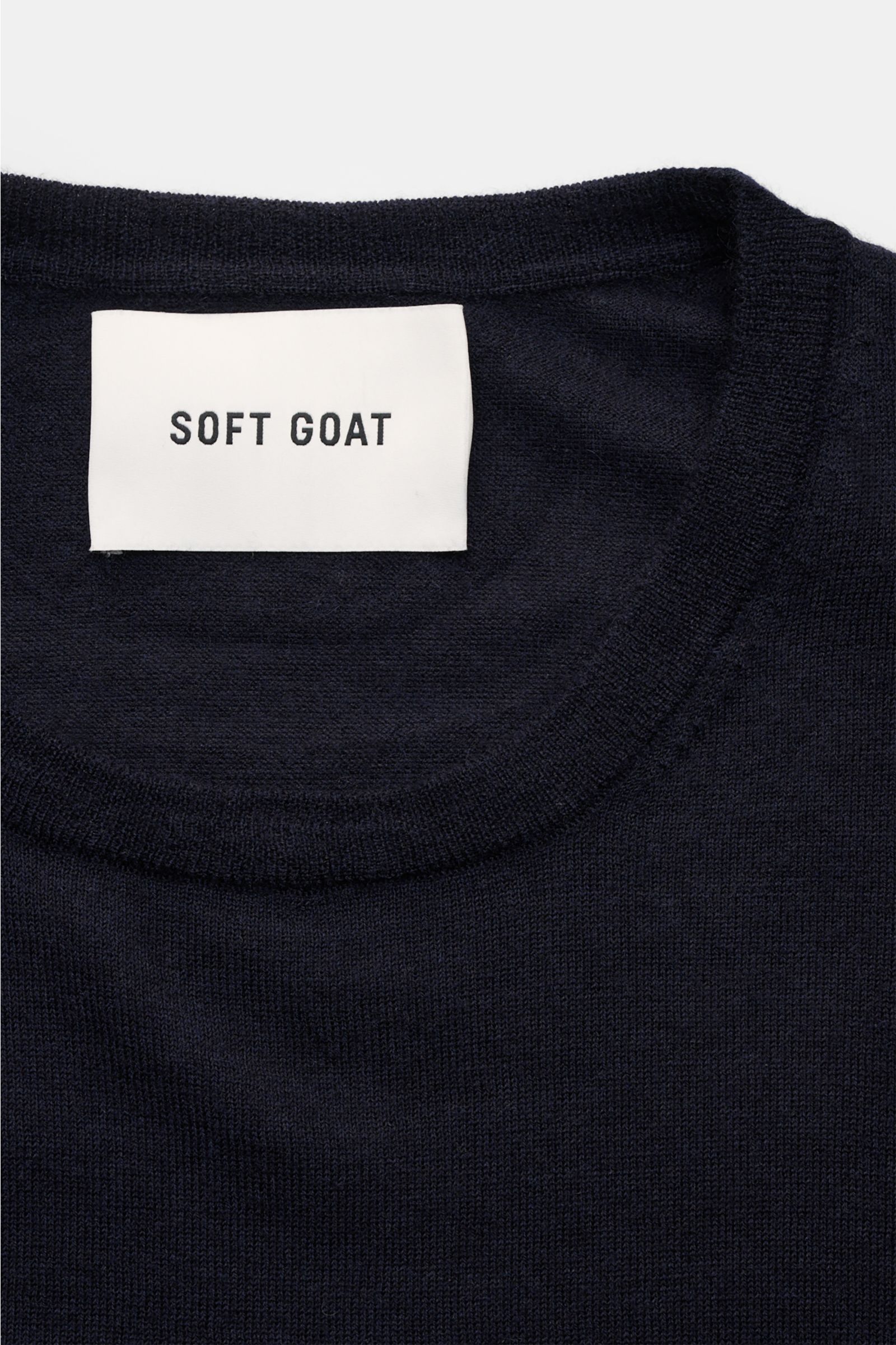 Close-up front view of Soft Goat Cashmere crew neck jumper navy showing fine knit, crew neck, ribbed bands, and brand label.

Description: Sustainably produced and certified: Young label SOFT GOAT shows how it’s done with its super lightweight cashmere