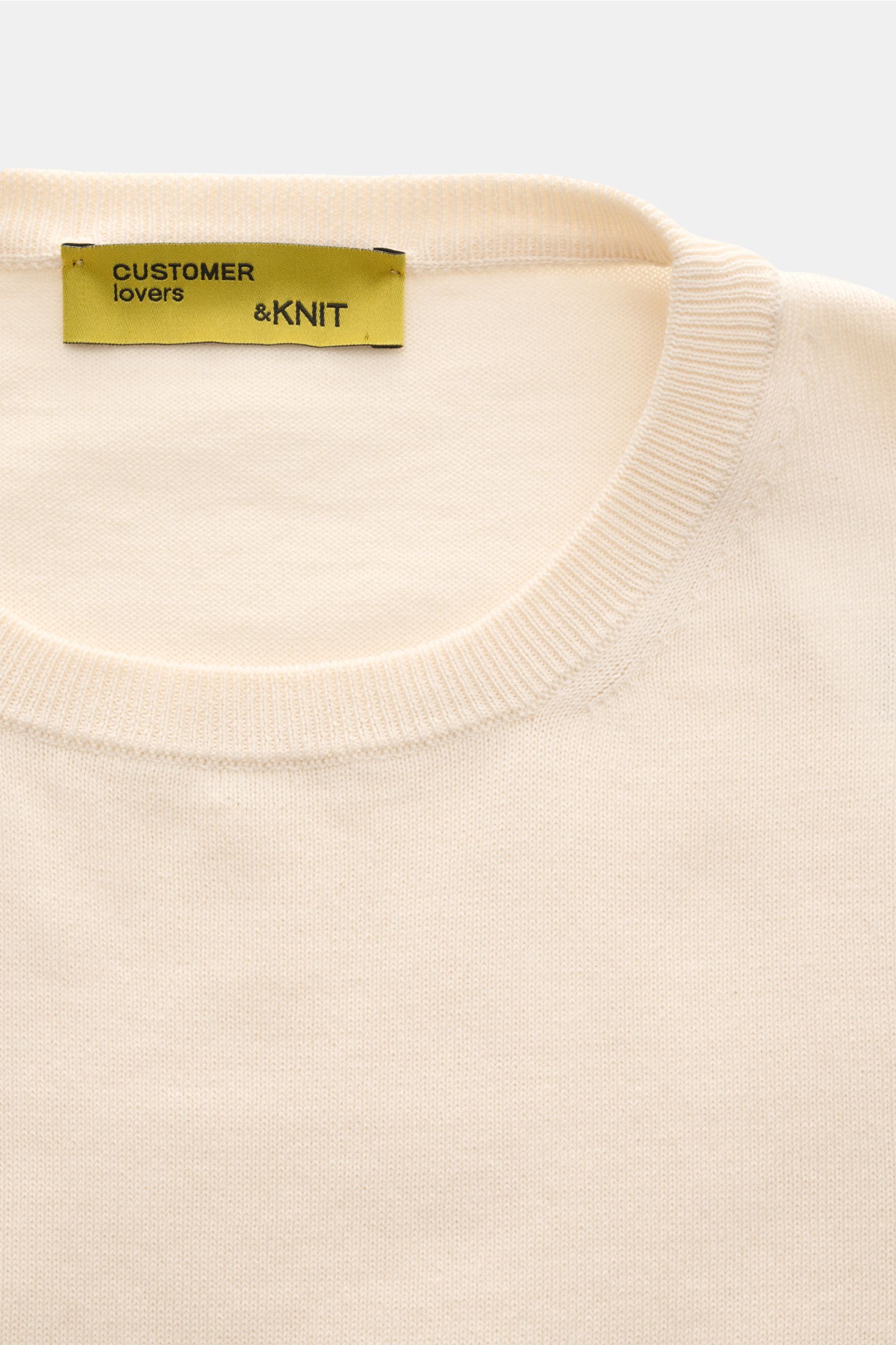 Close-up front view of B.F. Knitwear Crew neck jumper cream showing fine knit, slim fit, soft pure cotton fabric, and ribbed crew neck bands.

A versatile essential for spring: This crew neck jumper in pure cotton by B.F. KNITWEAR enhances any wardrobe