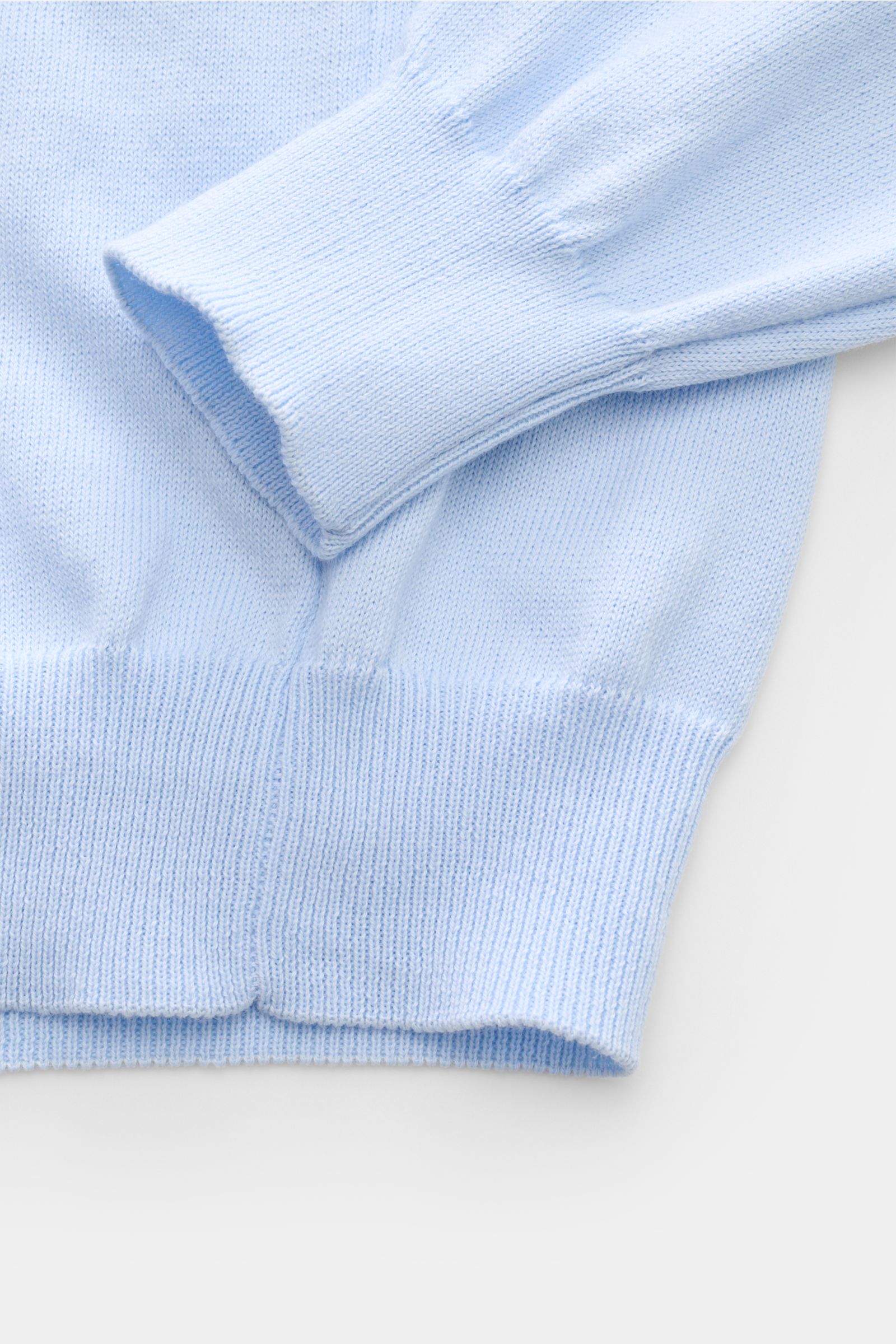Close-up of the B.F. Knitwear Crew neck jumper light blue, photographed from above showing fine knit, slim fit, ribbed cuffs and hem in pure cotton. 

Description: A versatile essential for spring: This crew neck jumper in pure cotton by B.F. KNITWEAR enh