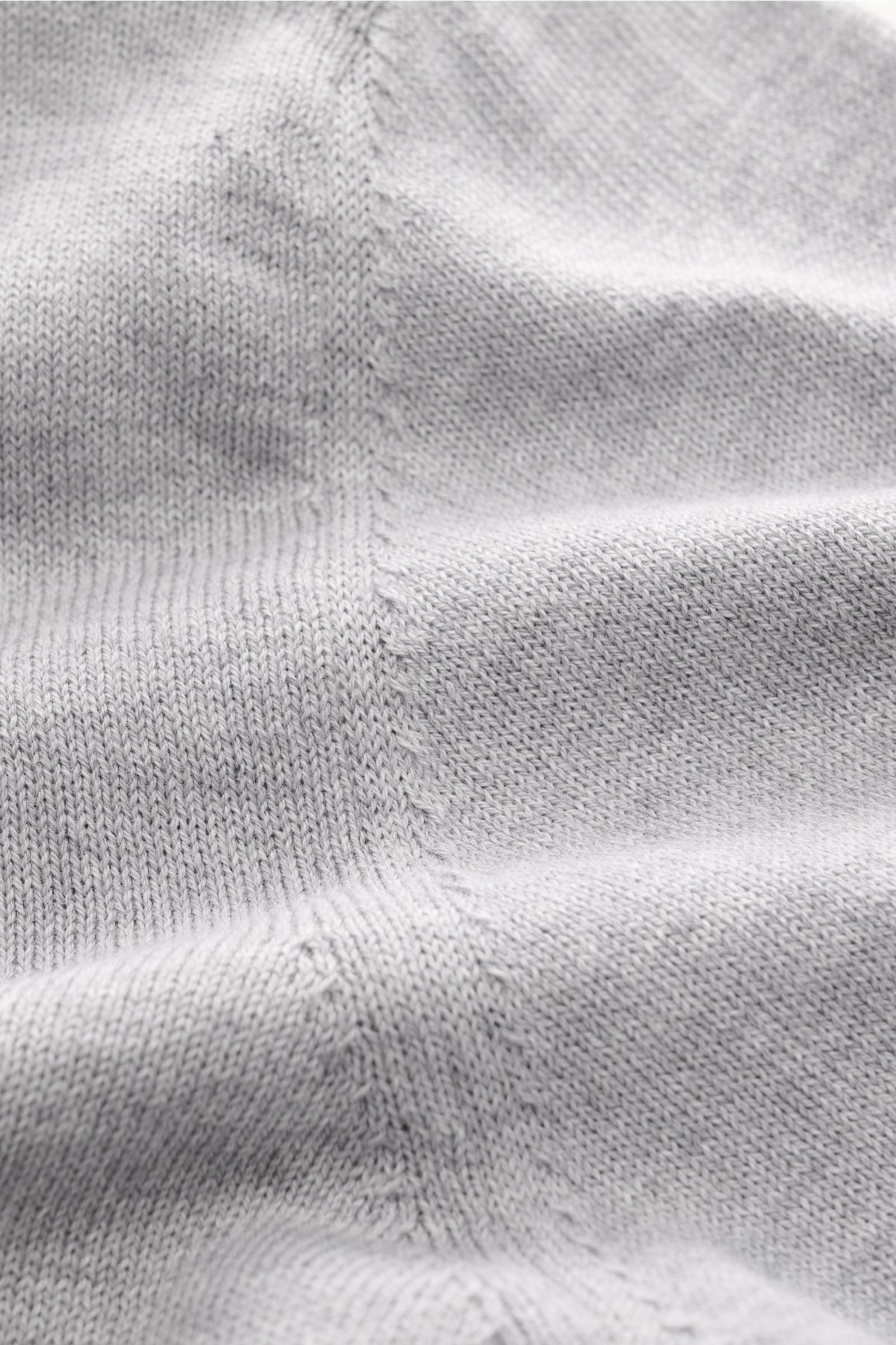 Nahaufnahme des grauen melierten B.F. Knitwear Rundhalspullovers aus reiner Baumwolle mit feinem Strickbild, Slim Fit, Rundhalsausschnitt und Rippbündchen, detailreich von schräg oben fotografiert.