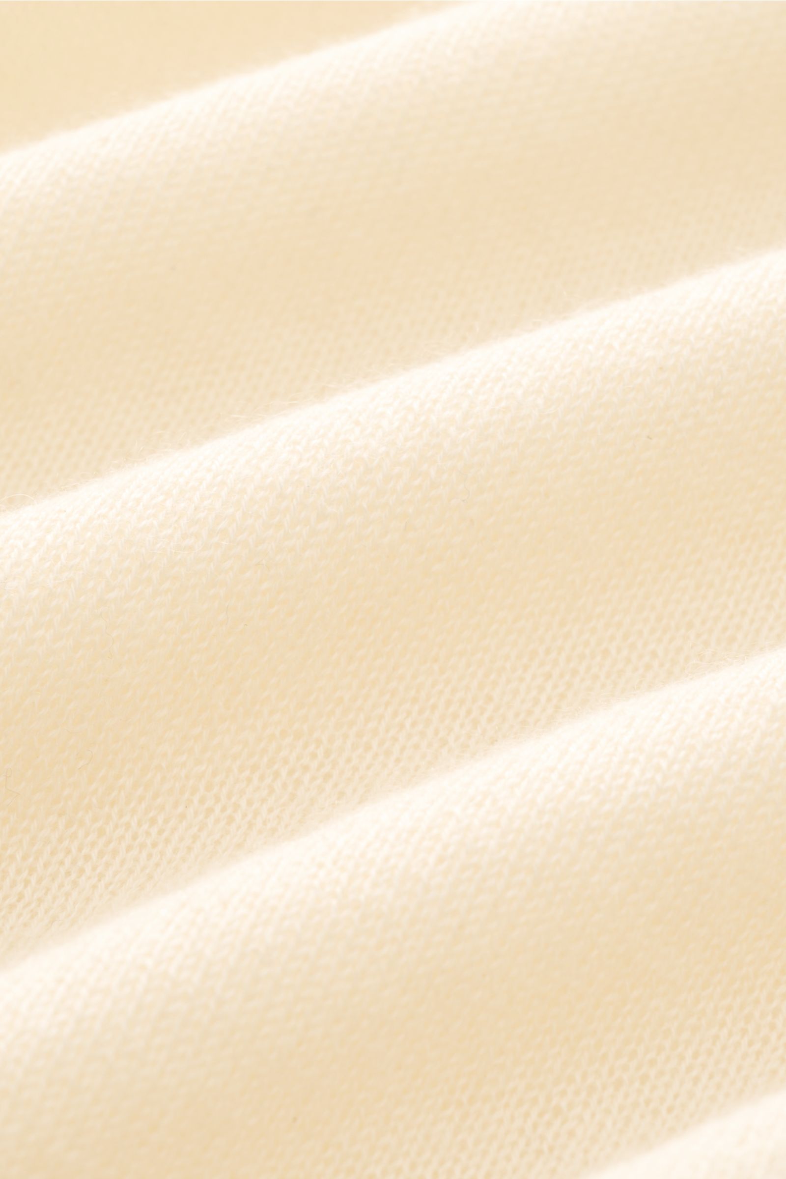 Close-up texture of the cream fabric of the B.F. Knitwear Cashmere crew neck jumper, photographed from a top angle showing fine, airy knit.

Description: Lightweight summer cashmere from knitwear experts B.F. KNITWEAR: enhance your spring wardrobe with