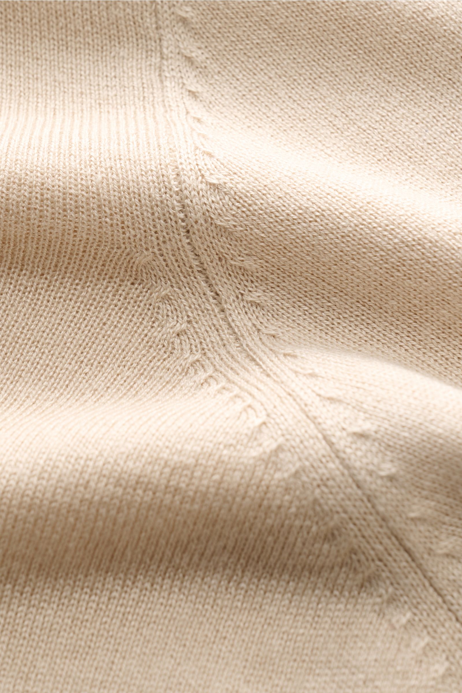 Close-up front view of the beige Della Ciana Feinstrick-Rundhalspullover 'Girocollo', showcasing its fine silk and cashmere knit, soft texture, slim fit, round neckline, and comfortable ribbed cuffs. 