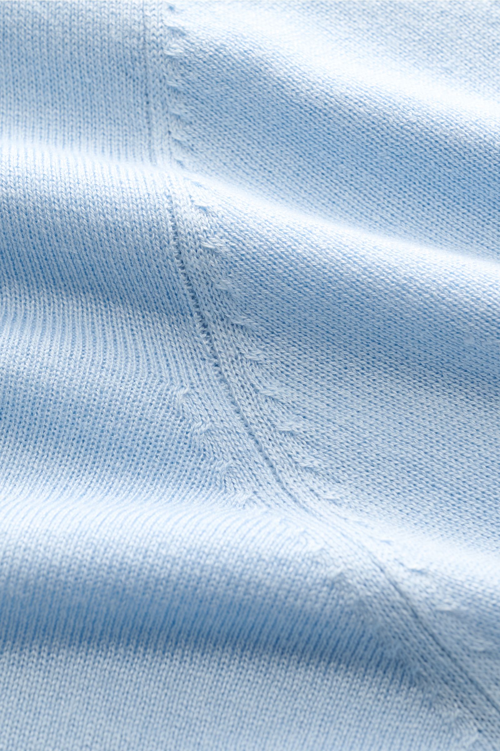 Close-up image from a top-down perspective showing the fine knit texture and stitching details of the pastel blue Della Ciana Feinstrick-Rundhalspullover 'Girocollo', made from a luxurious silk and cashmere blend with a soft touch and slim fit design, fea