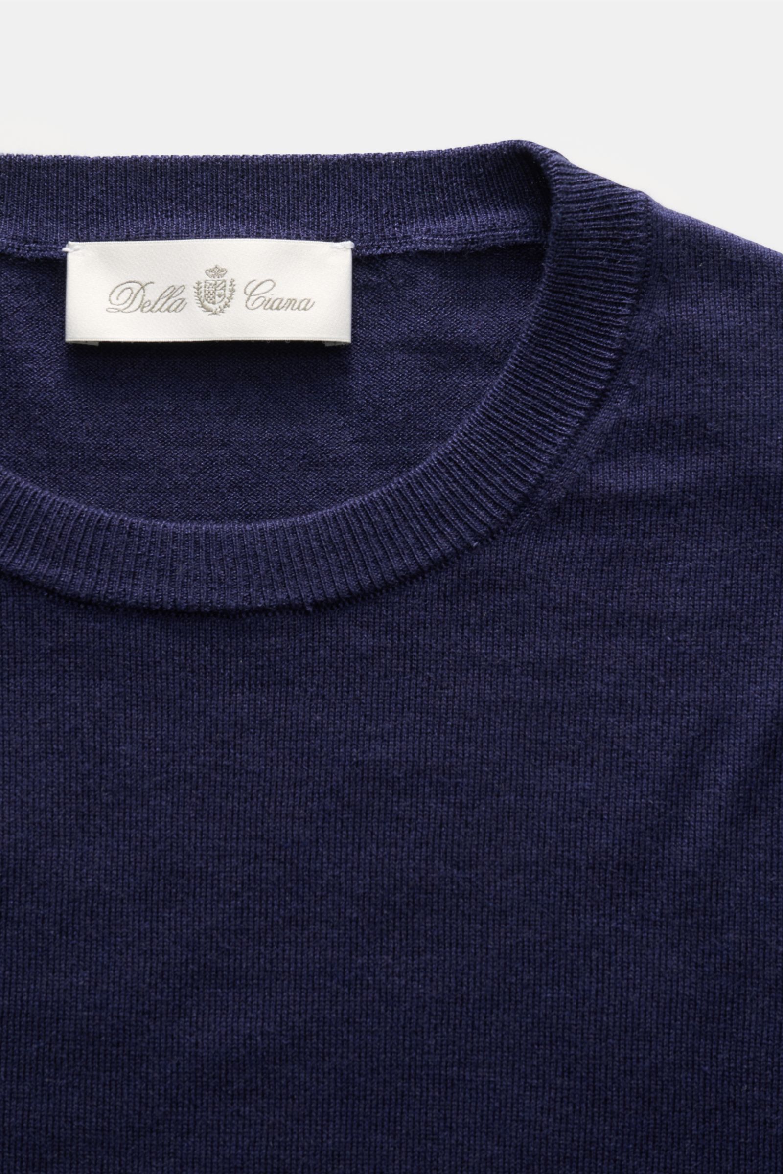 Close-up top-down view of the Della Ciana Feinstrick-Rundhalspullover 'Girocollo' navy, showing its fine knit, slim fit, round neckline, and ribbed collar with label; a luxurious silk-cashmere blend with a soft touch and lightweight, fine knit quality. 